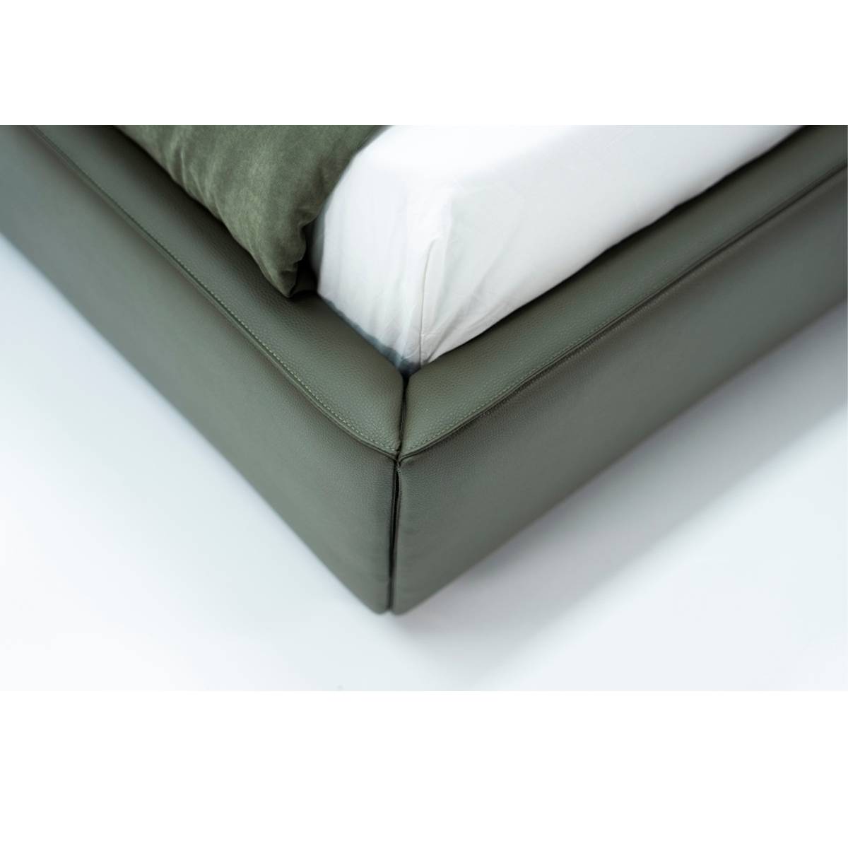 Close-up of the bed frame corner showing the leather wrapping and corner joint