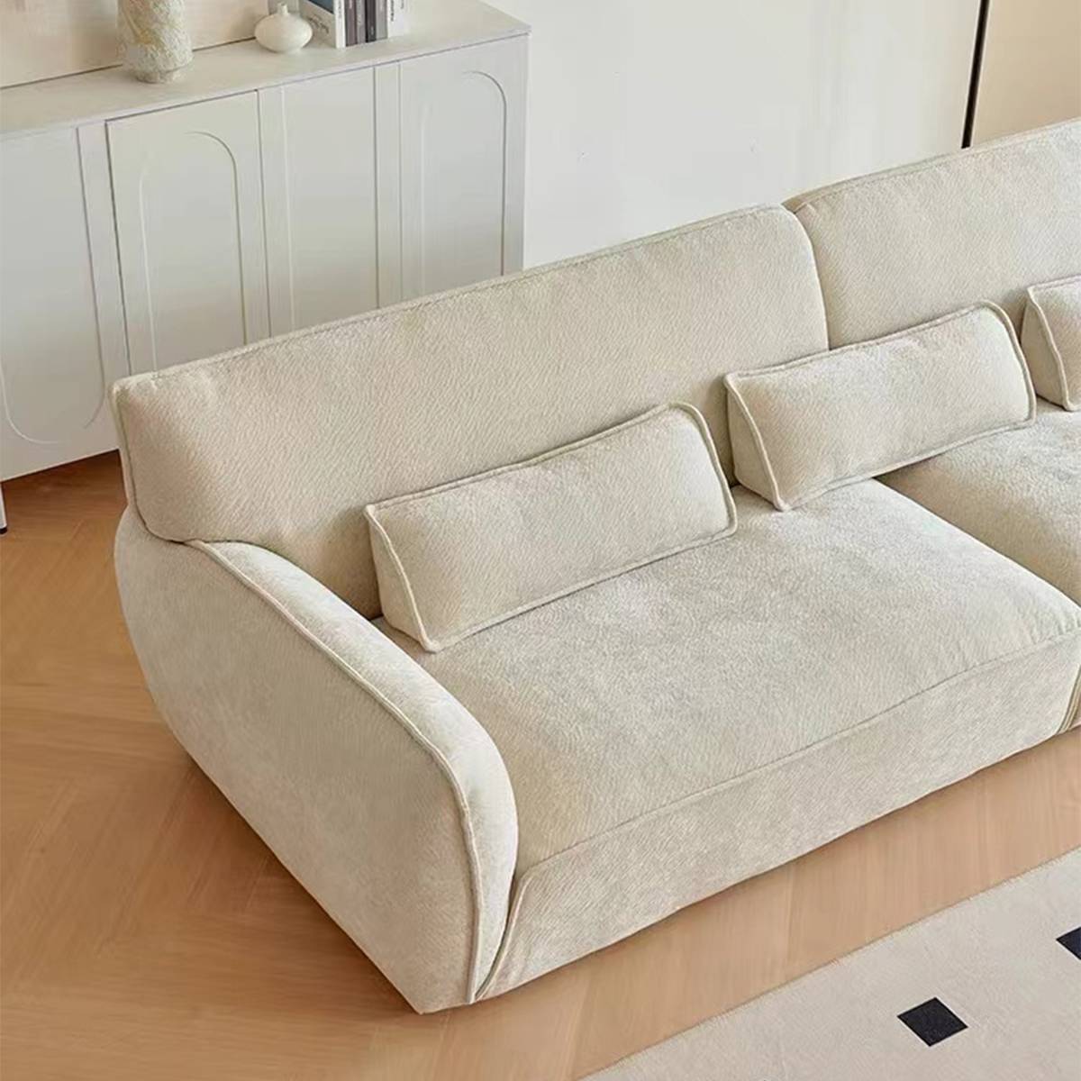Close-up detail of the beige sofa armrest and cushions