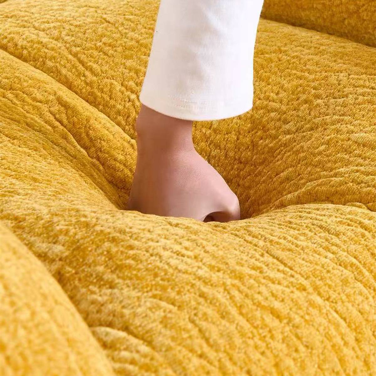 Close up of hand pressing into soft chair cushion