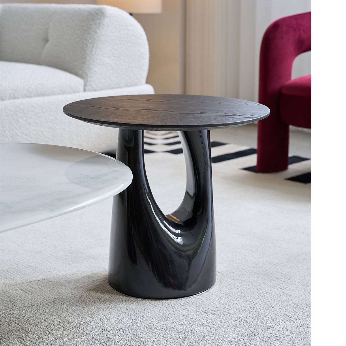 Side profile view of the black side table highlighting the curved base design.