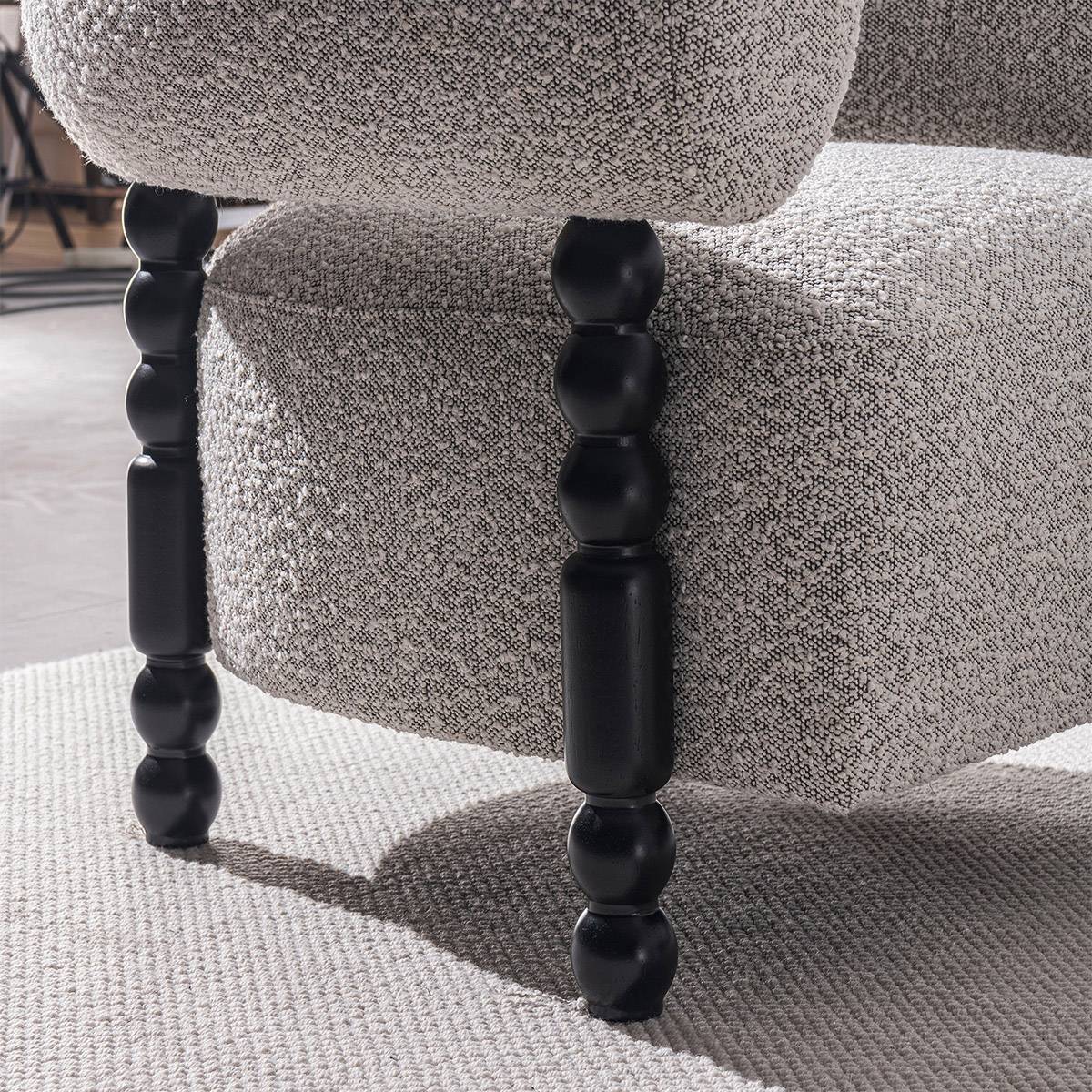 Close-up detail of the black turned wooden legs and fabric texture