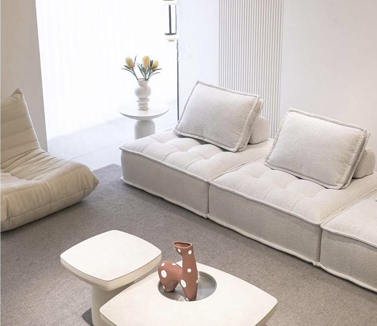 Beige modular sofa with matching pillows and a glass coffee table