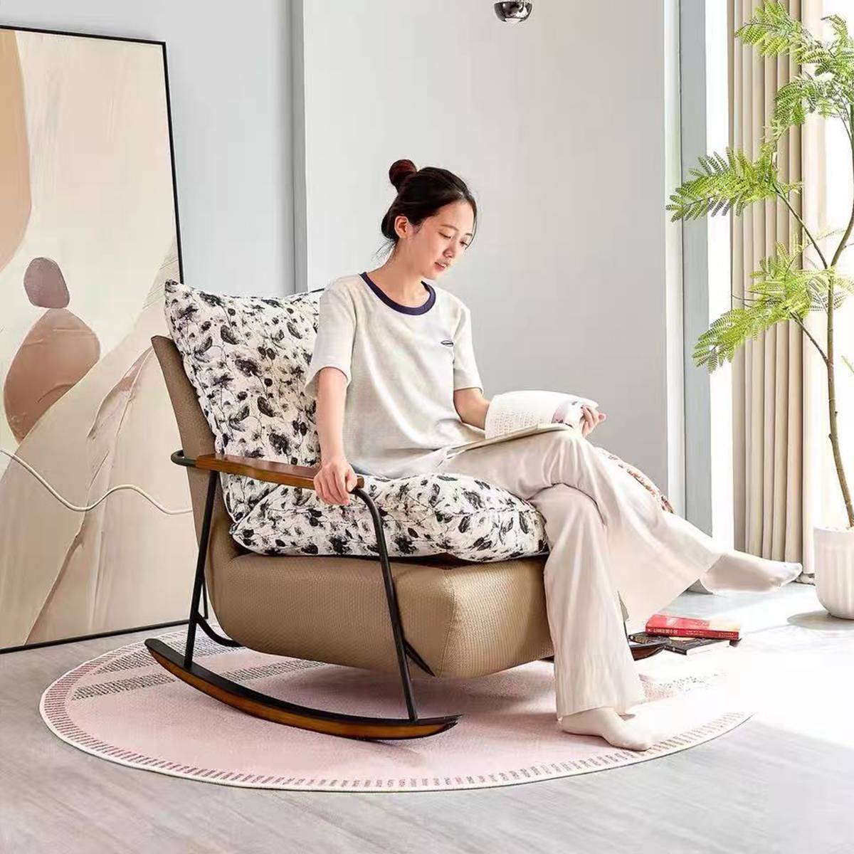 Model reading a book while sitting in the rocking lounge chair