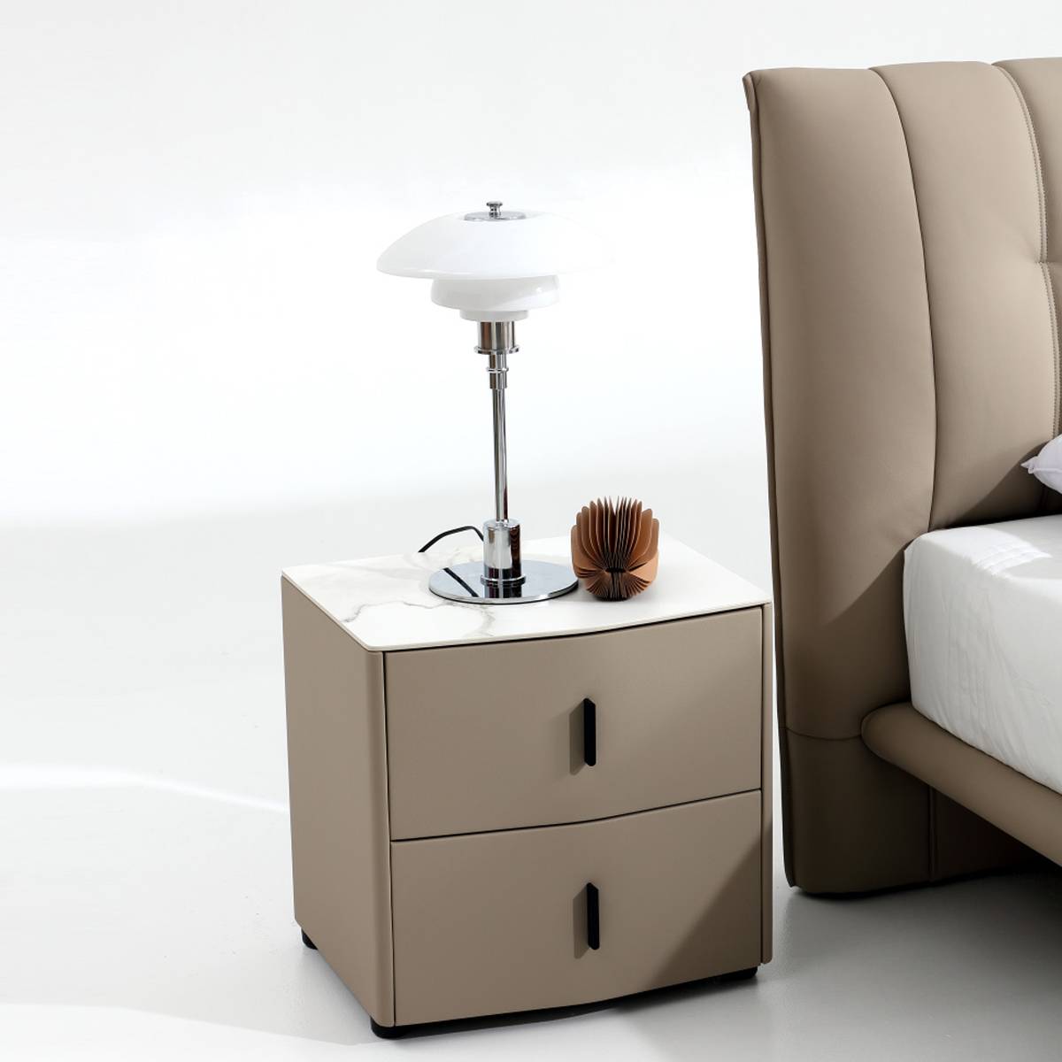 Close-up of the bedside table with a lamp and the side of the leather headboard