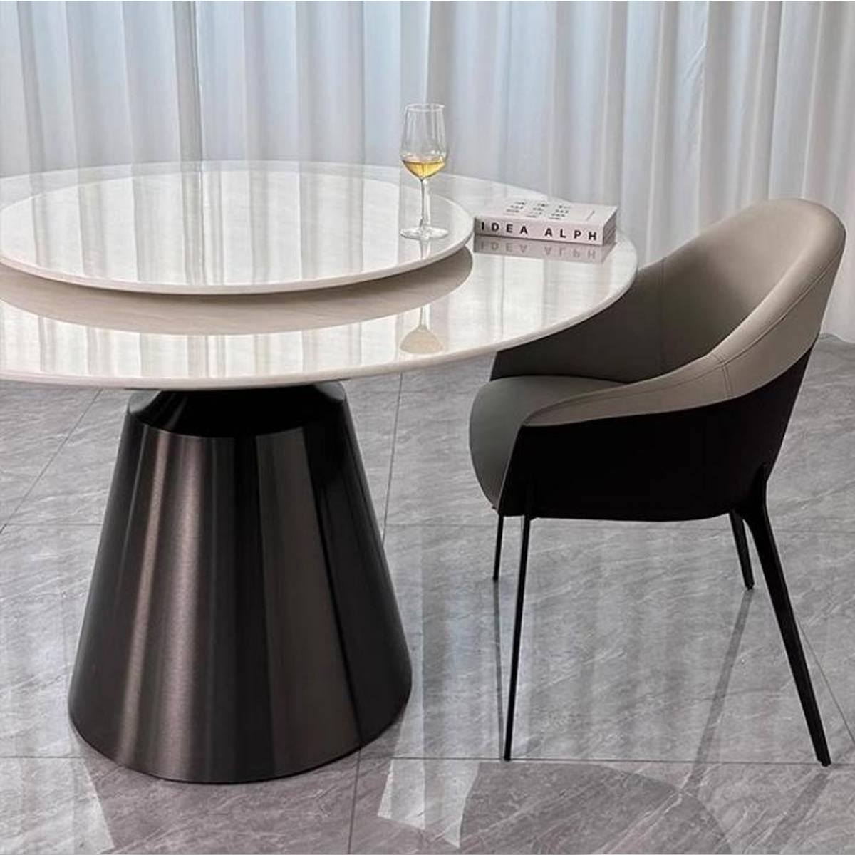 Side view of the round dining table showing the stainless steel bullet base and marble top
