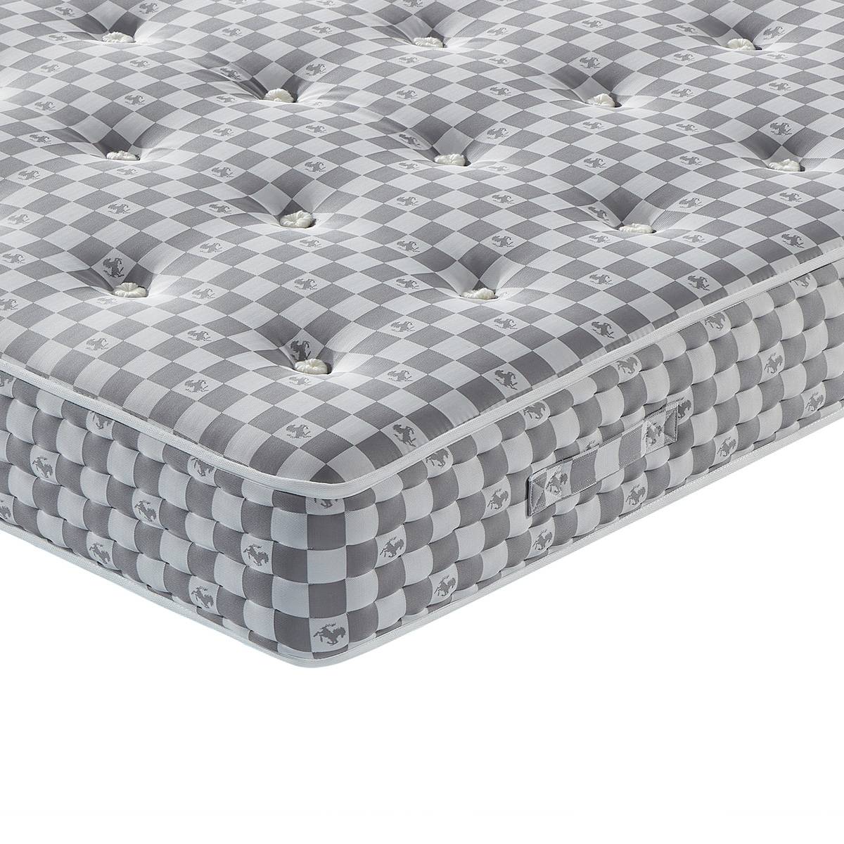 Close-up of the mattress corner showing tufted buttons and checkered fabric texture