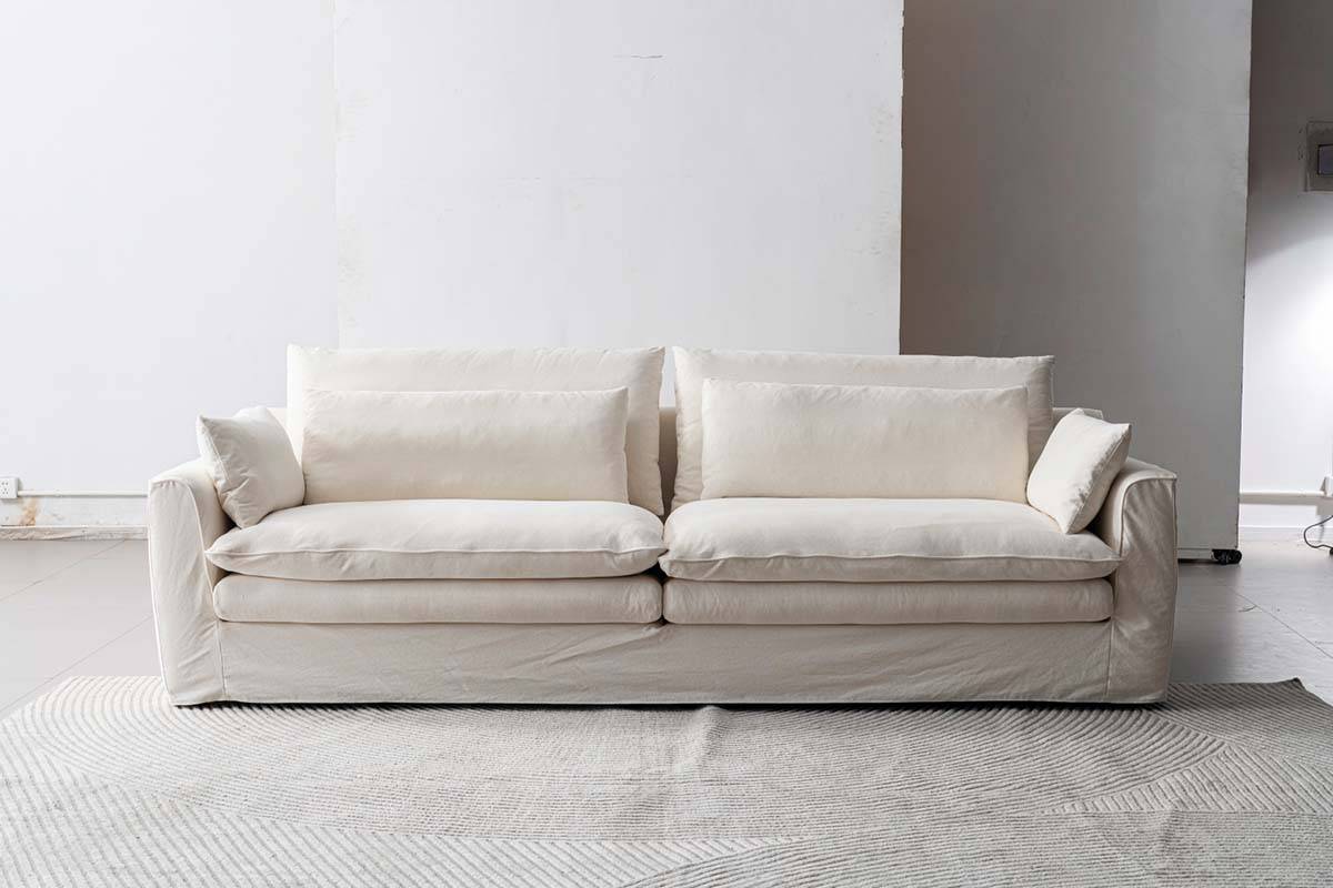 Full view of the white fabric sofa with cushions