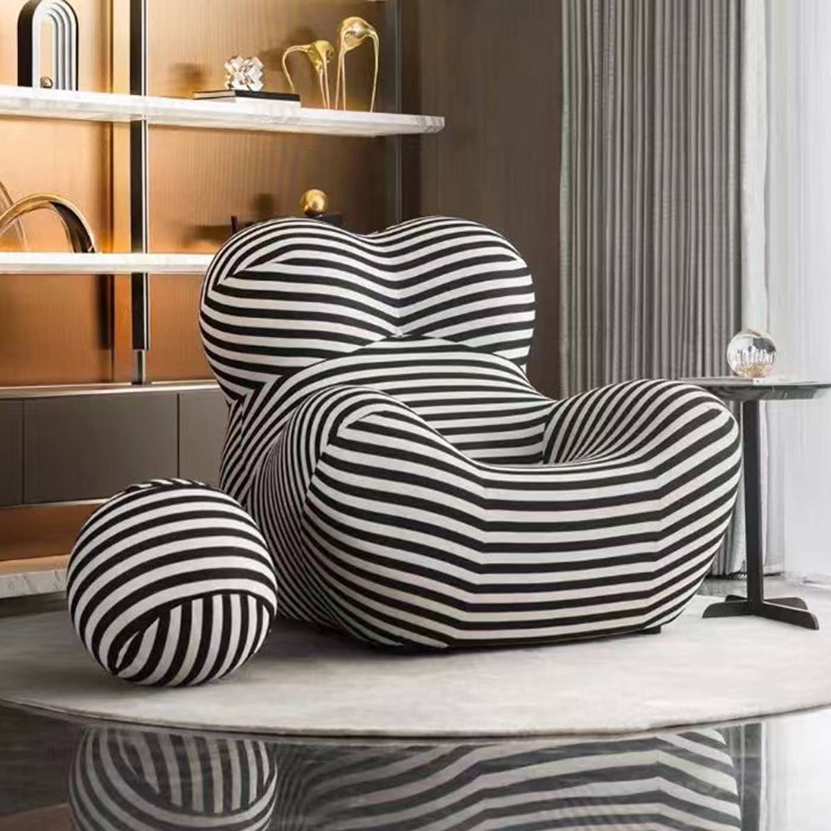 Black and white striped lounge chair with ottoman in a modern interior setting