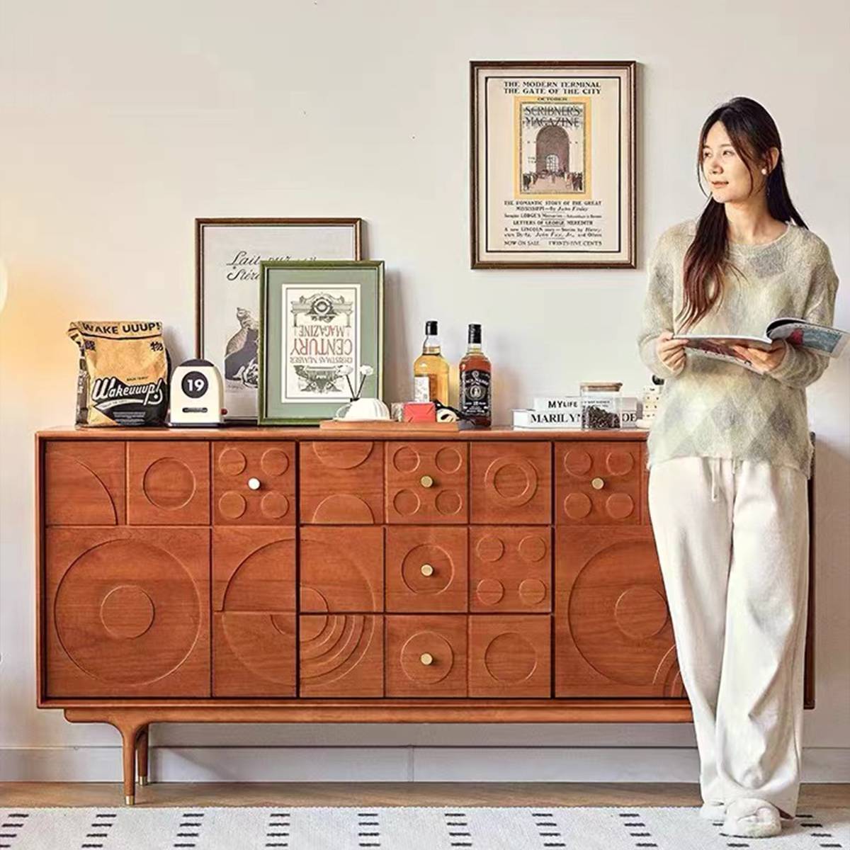 Sideboard styled with decor items and a person reading