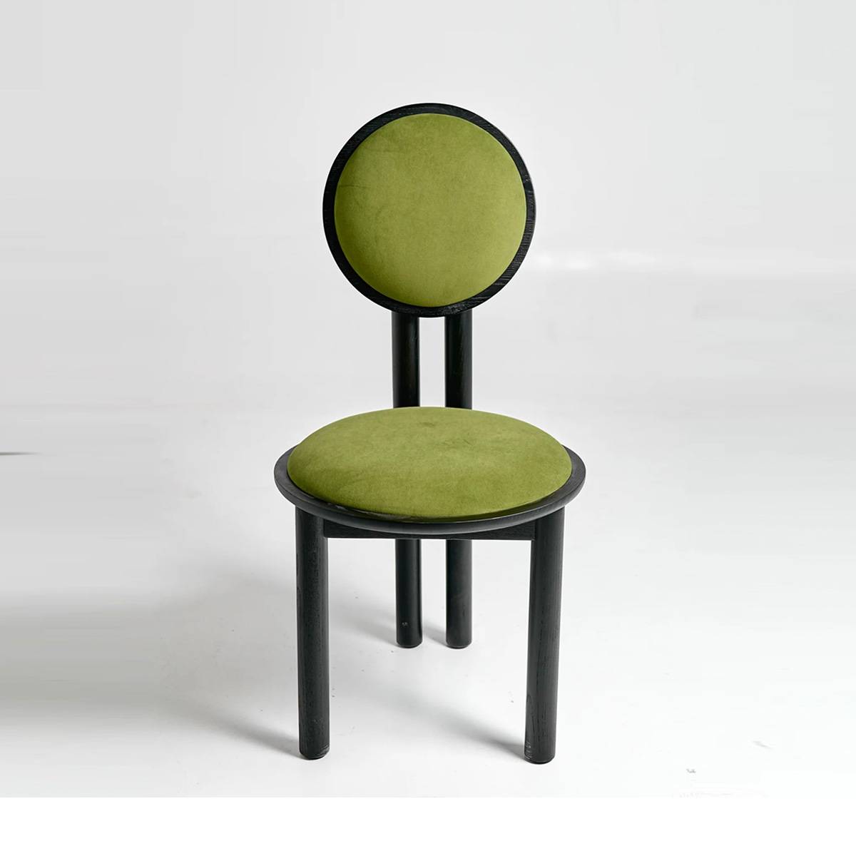 Front view of the black mid-century sun chair with green upholstery