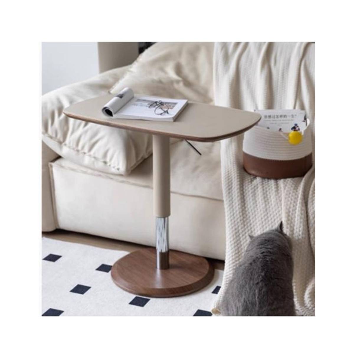 Adjustable side table placed next to a sofa with a cat nearby