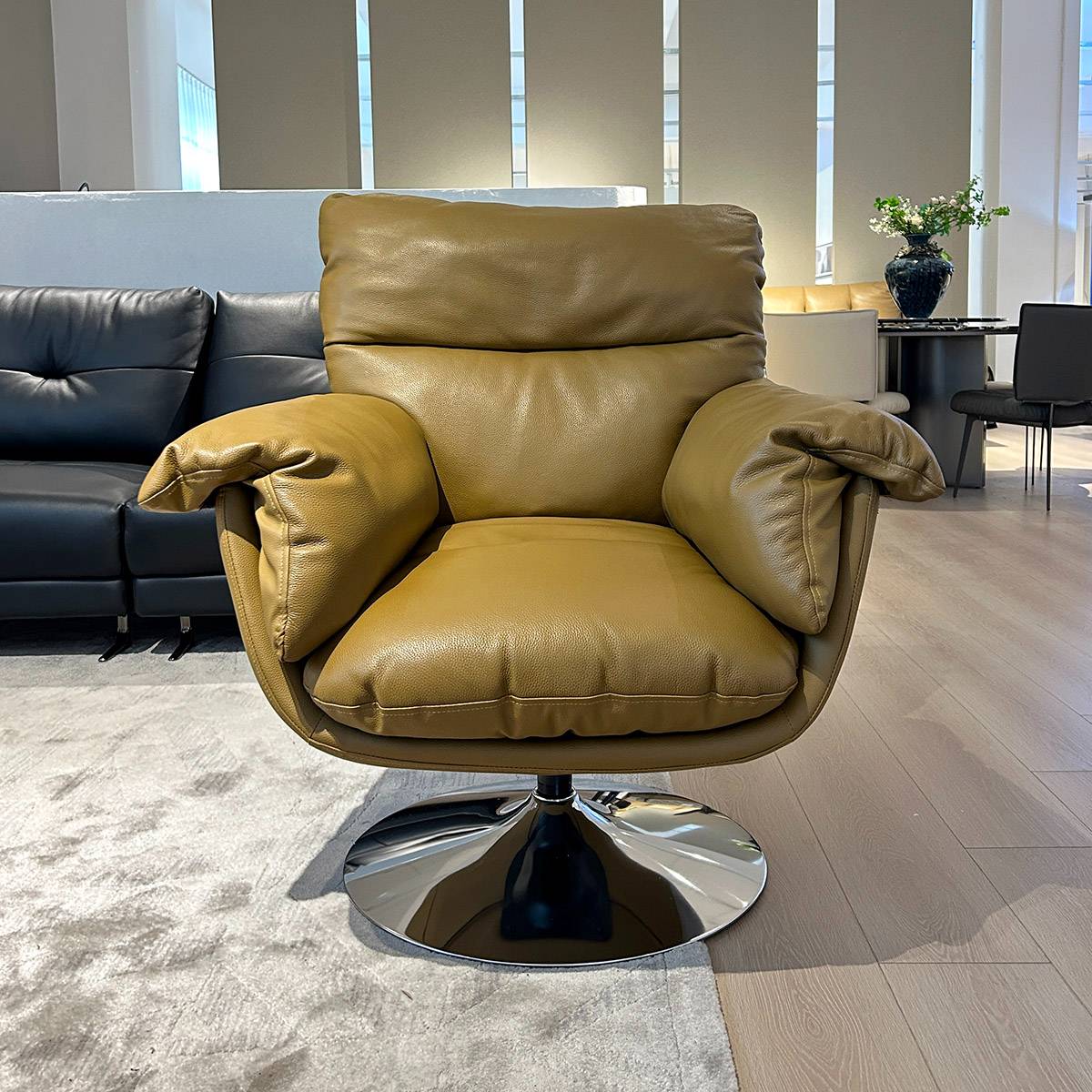 Front view of a tan leather swivel lounge chair with a chrome base