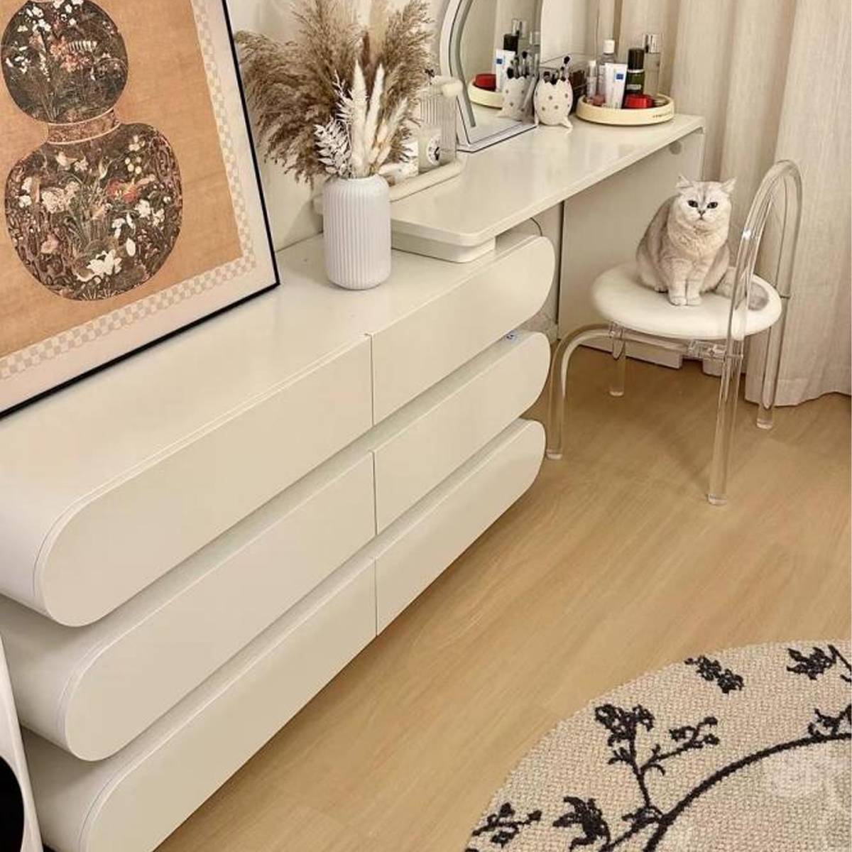 Close-up view of the vanity drawers and stool with a cat sitting on it