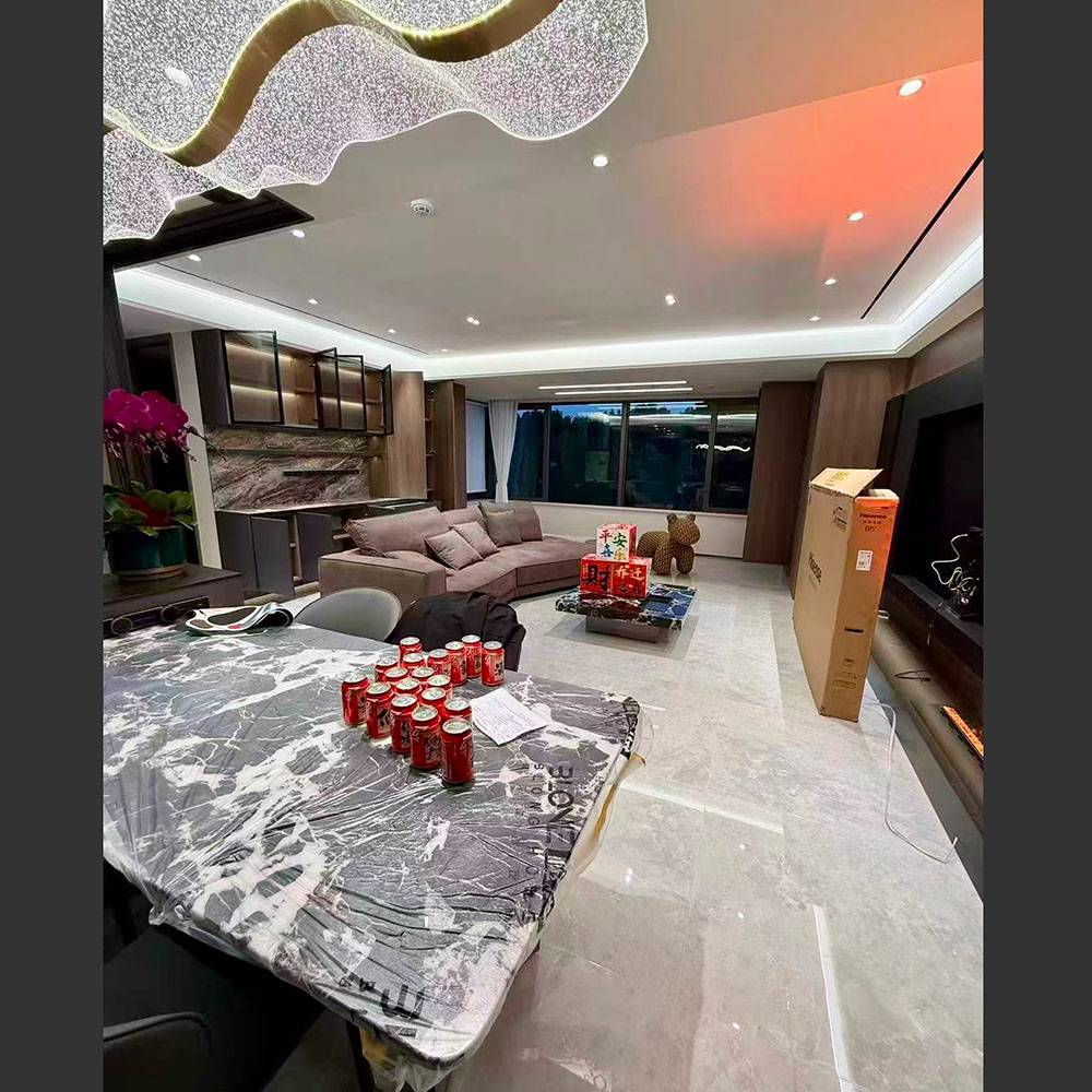 Wide view of the living room showing the Budapest fabric sofa, marble coffee table, and TV wall unit.