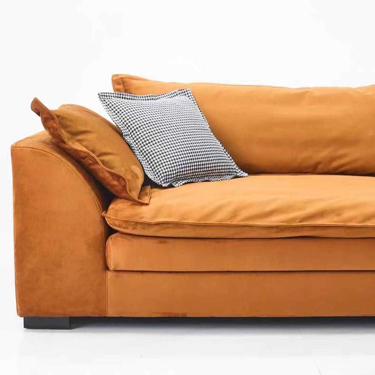 Close-up view of the orange matte fabric sofa showing the texture and a checkered throw pillow