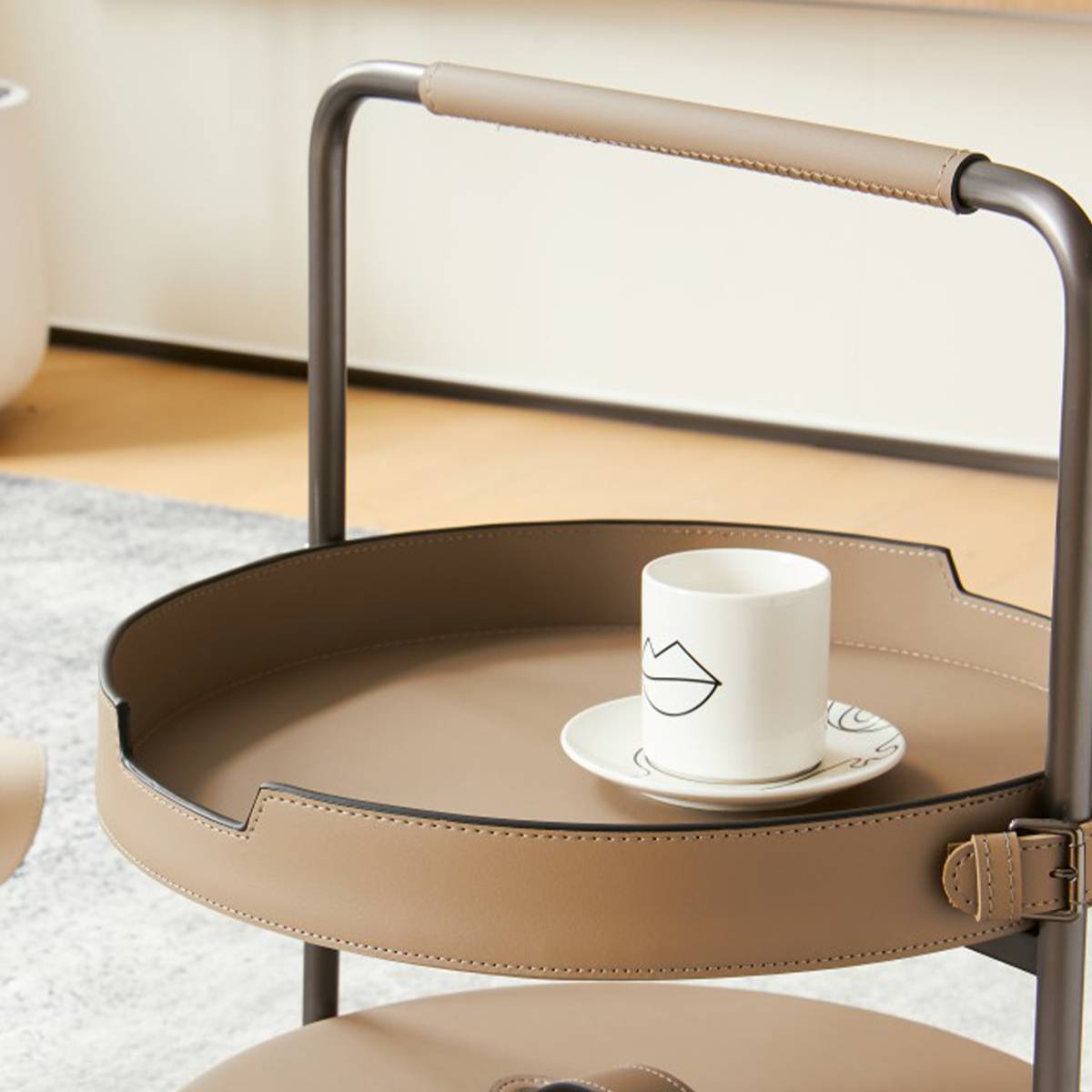 Close-up of the top tray showing the leather rim and stainless steel handle