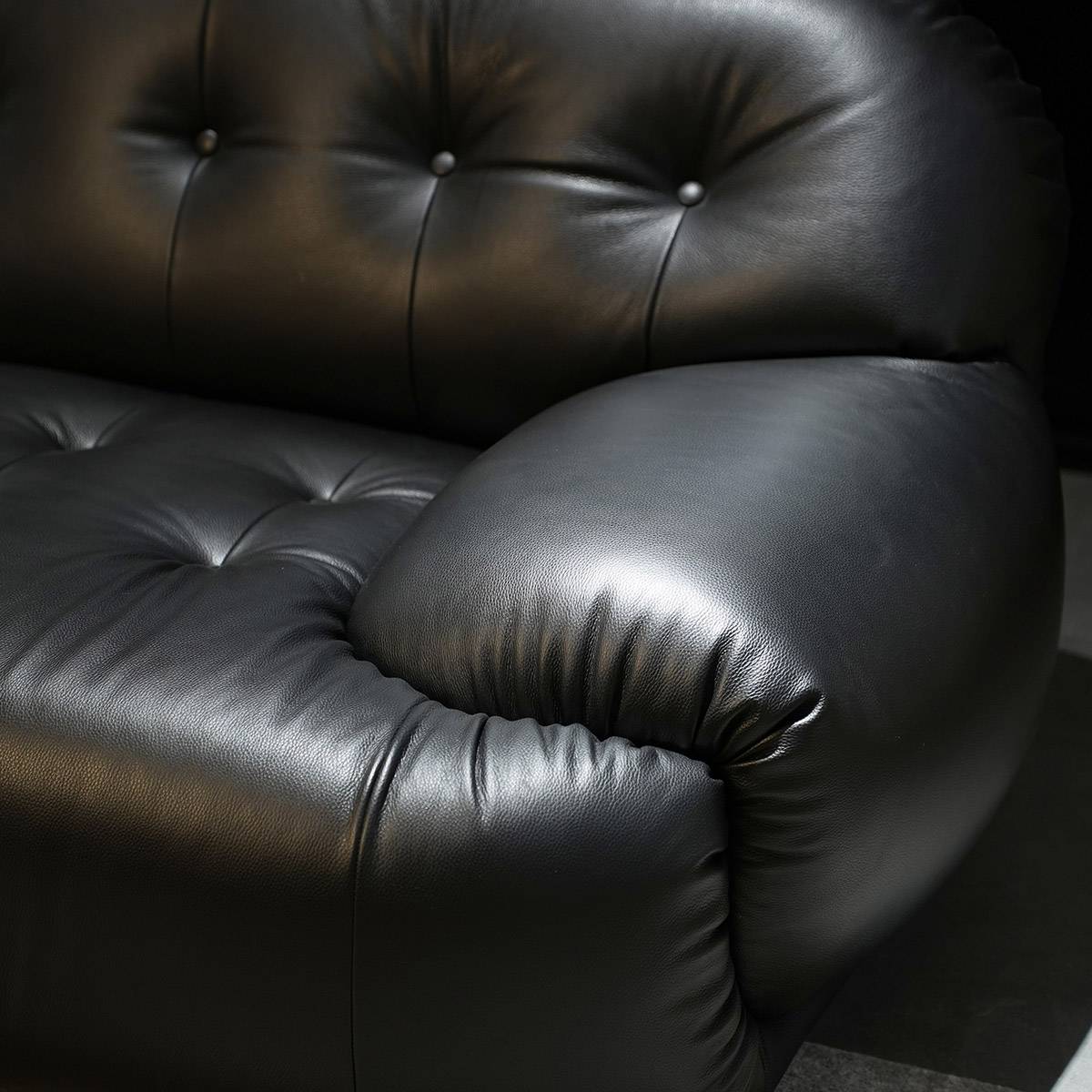 Close-up of the sofa armrest and tufted backrest detail