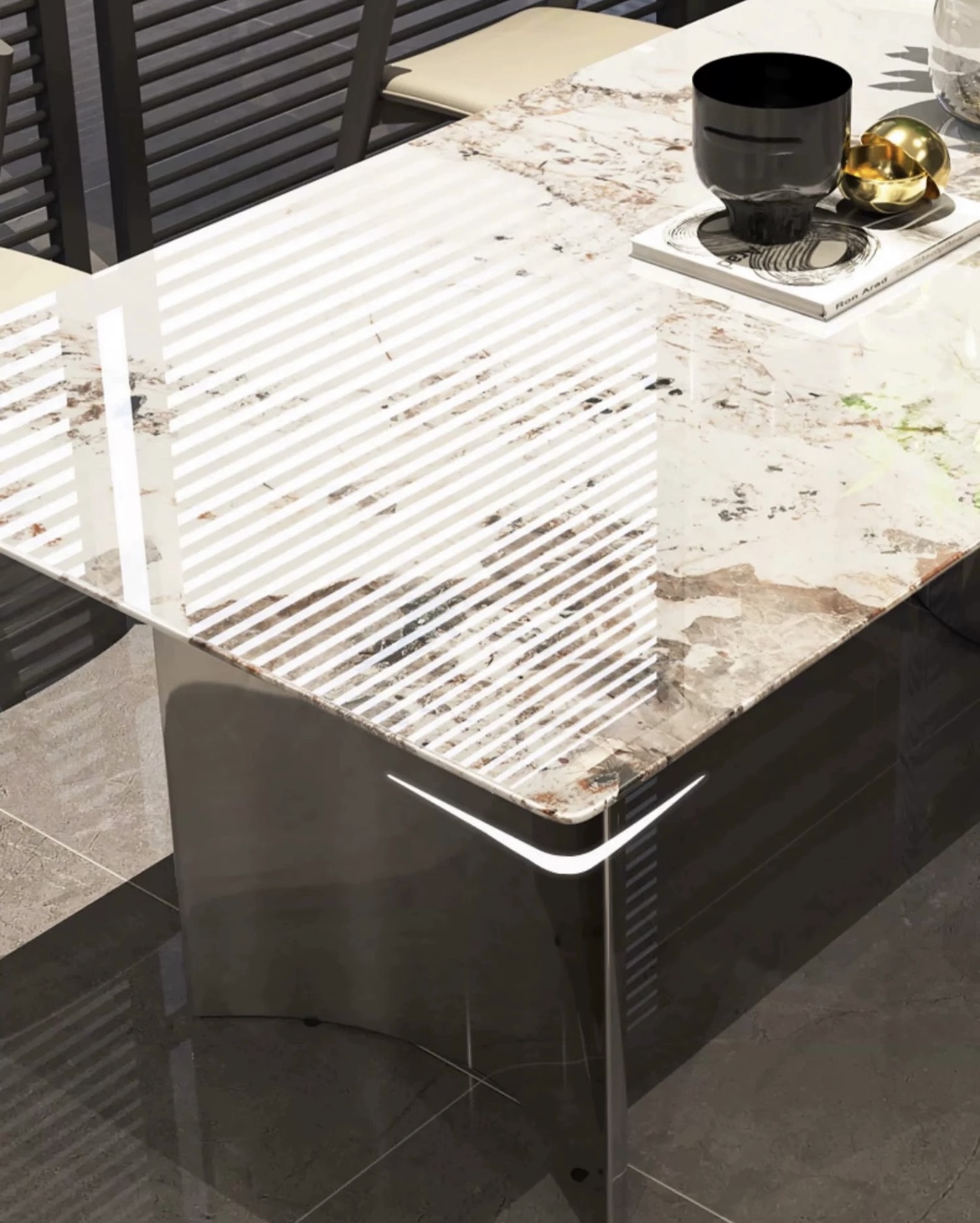 Close-up detail of the marble tabletop surface and the curved edge of the stainless steel base.
