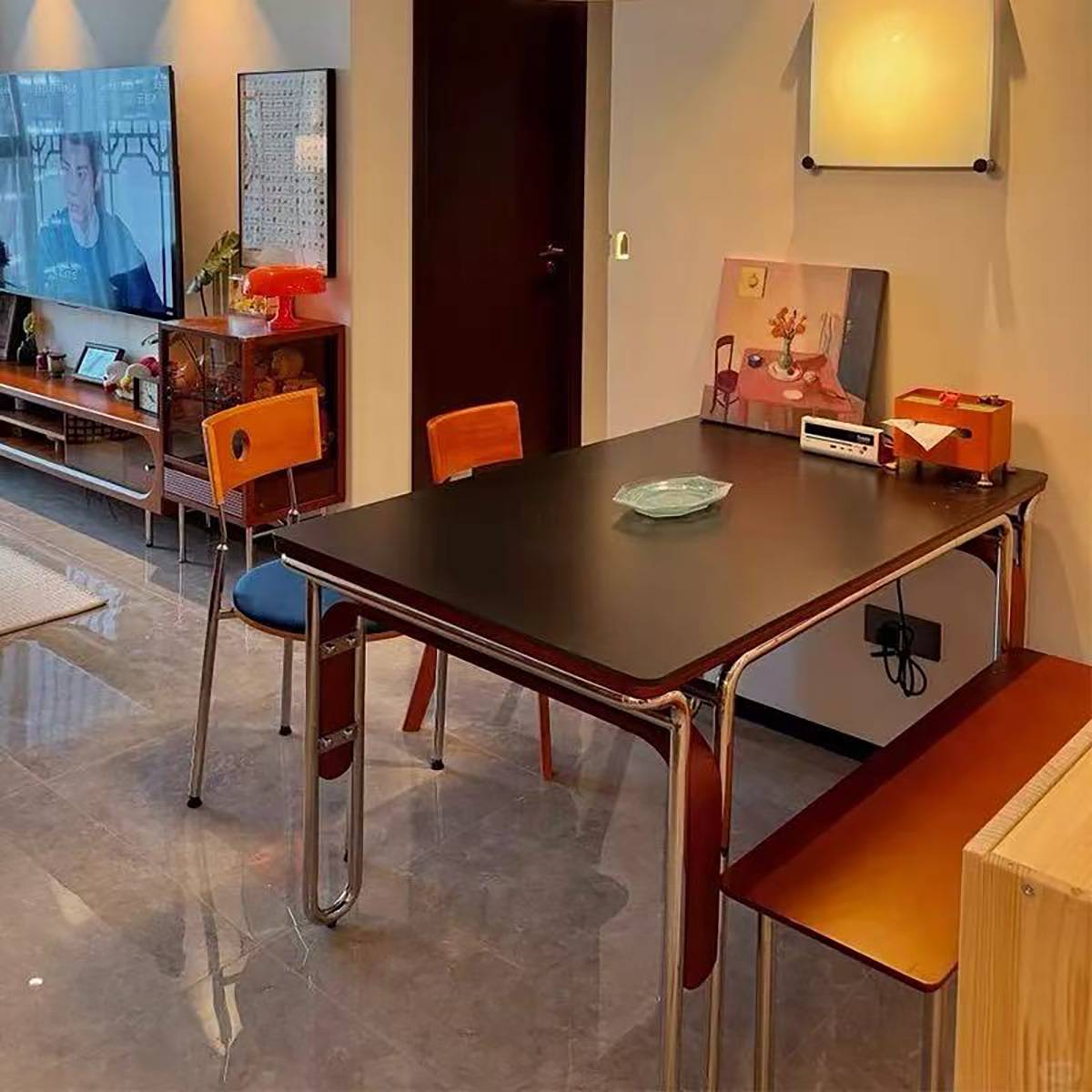 Black sintered stone dining table with stainless steel frame in a living room setting