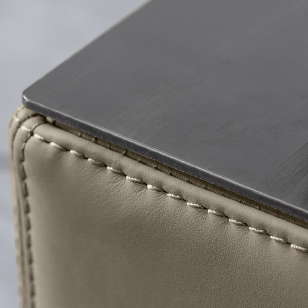 Close-up detail of sofa stitching and metal edge