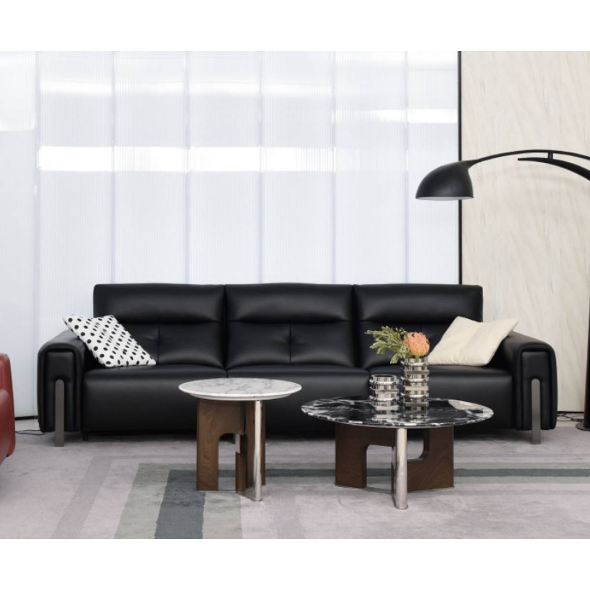 Front view of the black sofa with coffee tables and floor lamp