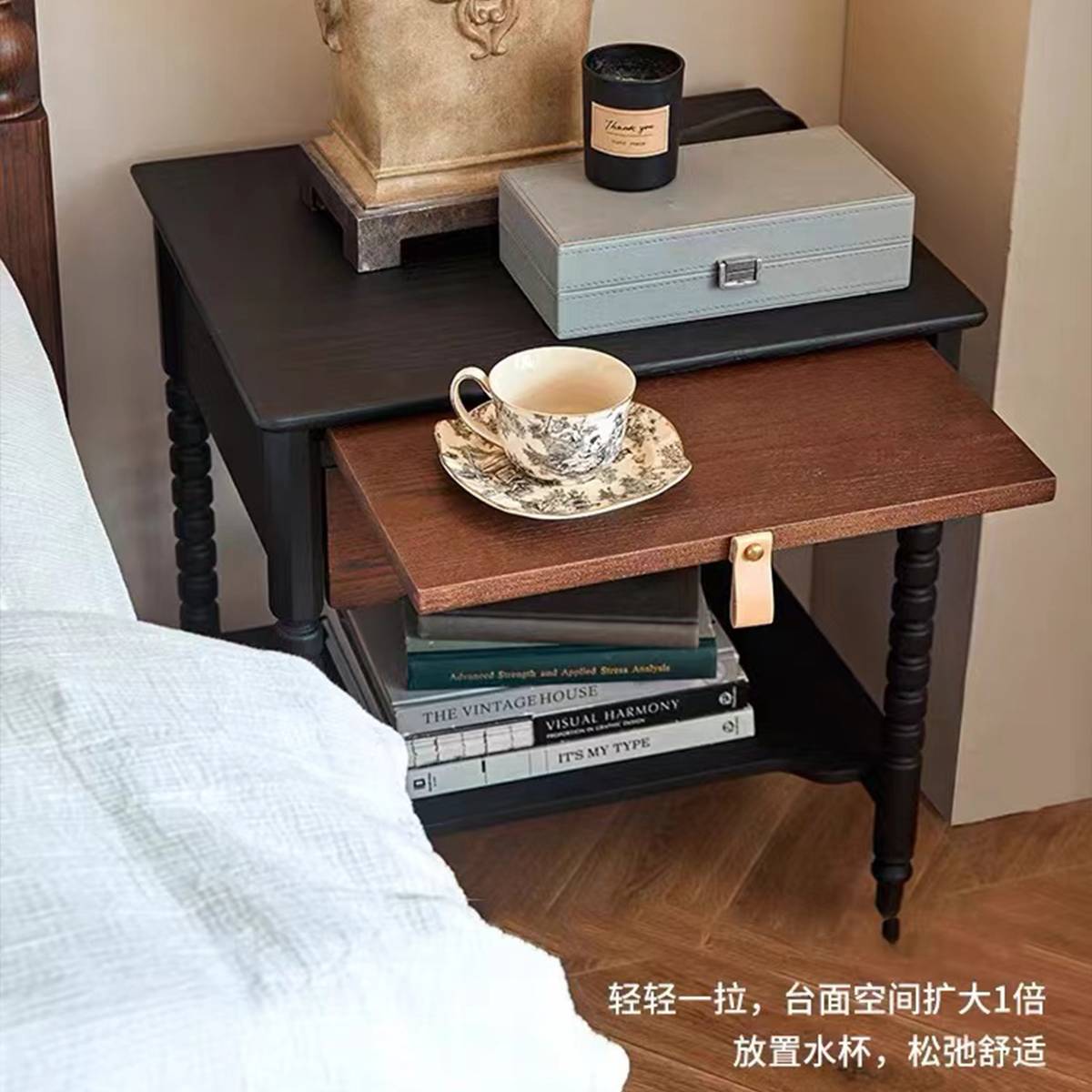Side view of the bedside table showing the turned legs and lower shelf with books