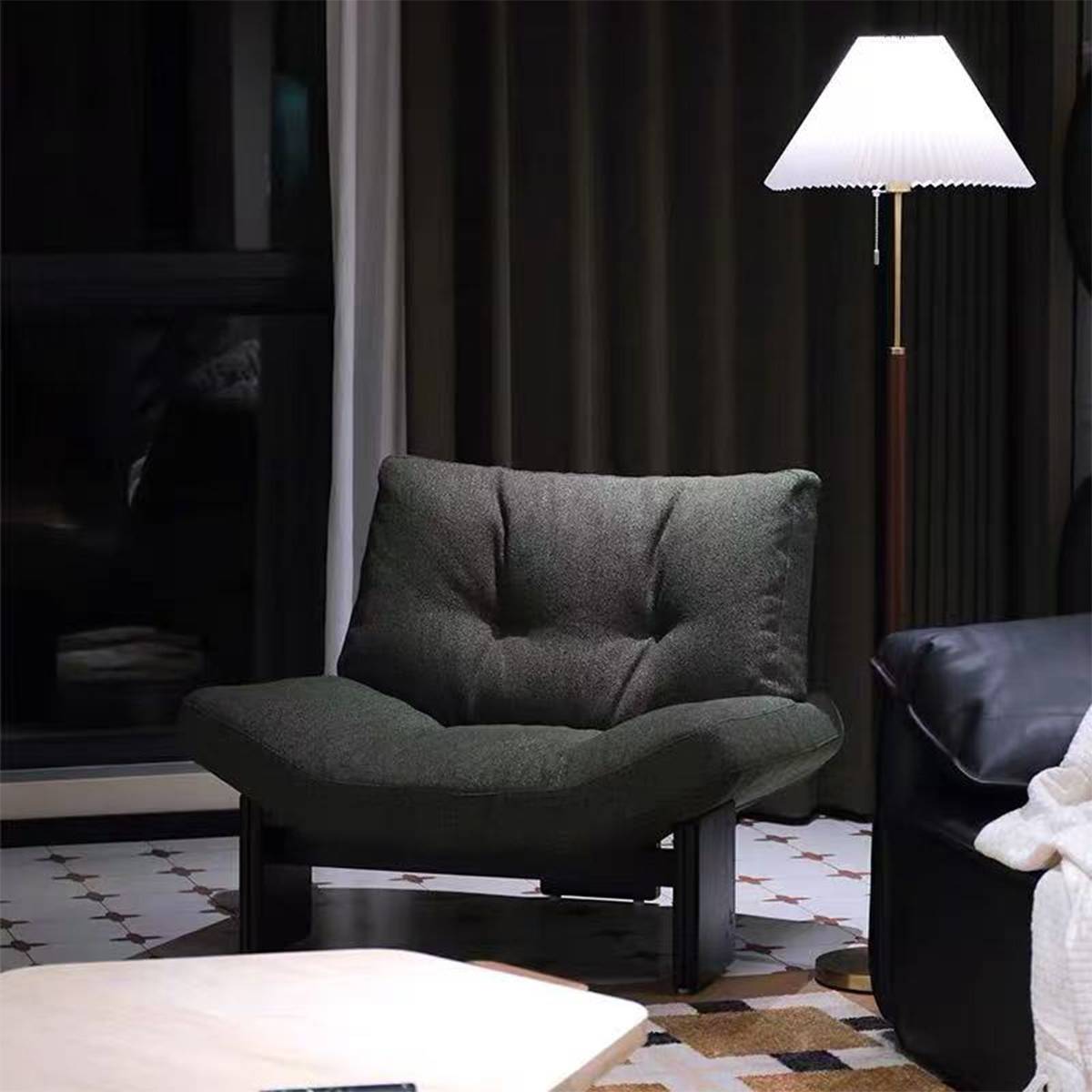 Green lounge chair next to a floor lamp in a living room