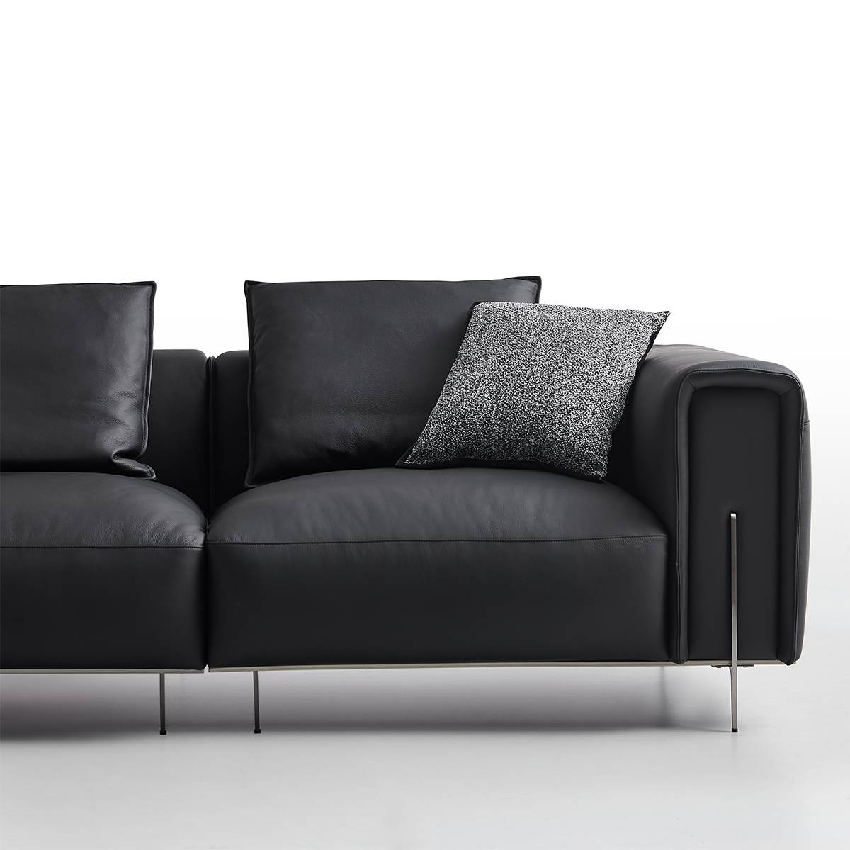 Front view of the black leather sofa showing the seat cushions and backrest