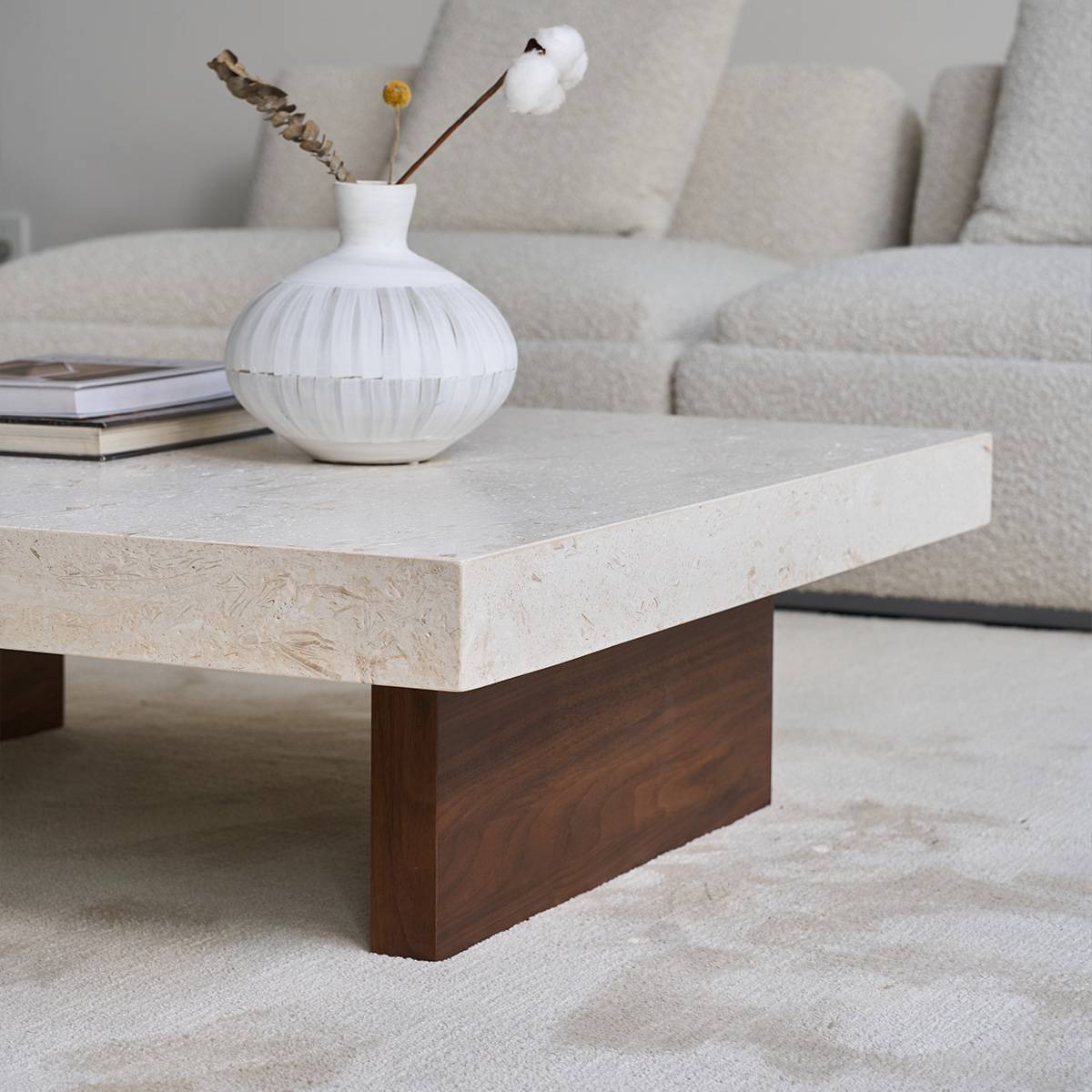 Close-up side view of the coffee table showing the dark wood base and stone edge.