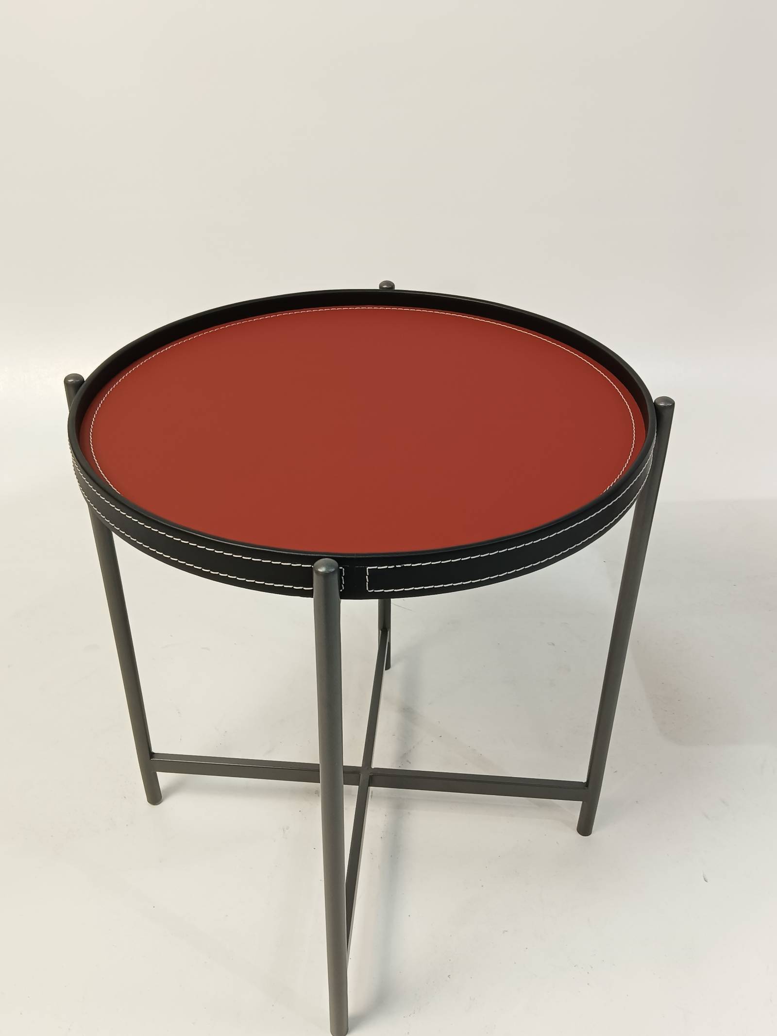Front view of the side table highlighting the stitching detail on the leather rim