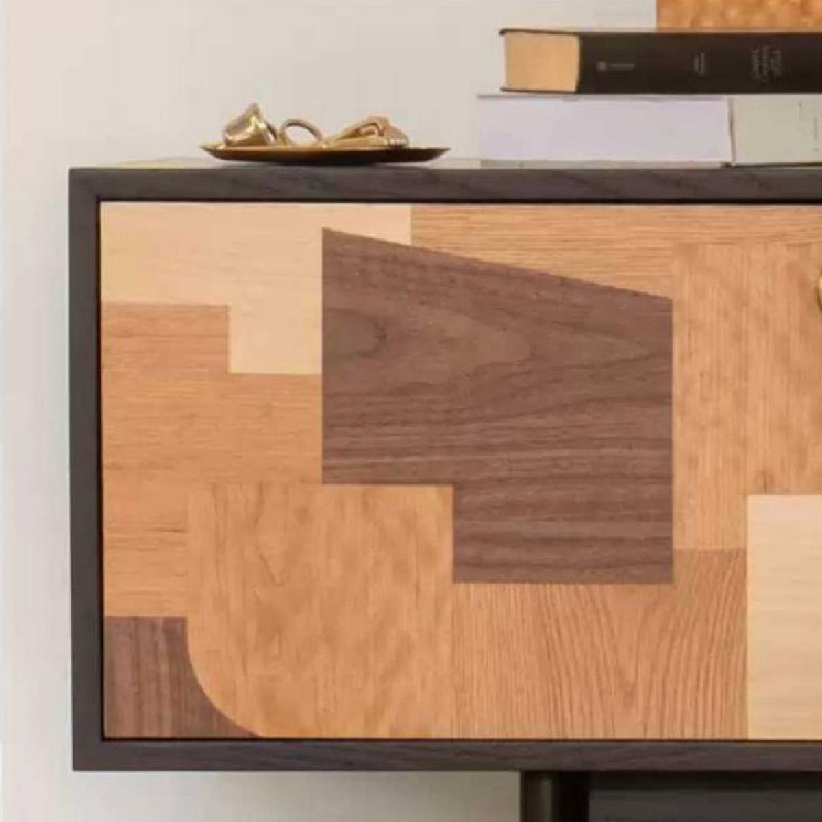 Close-up detail of the geometric wood patchwork pattern on the cabinet door