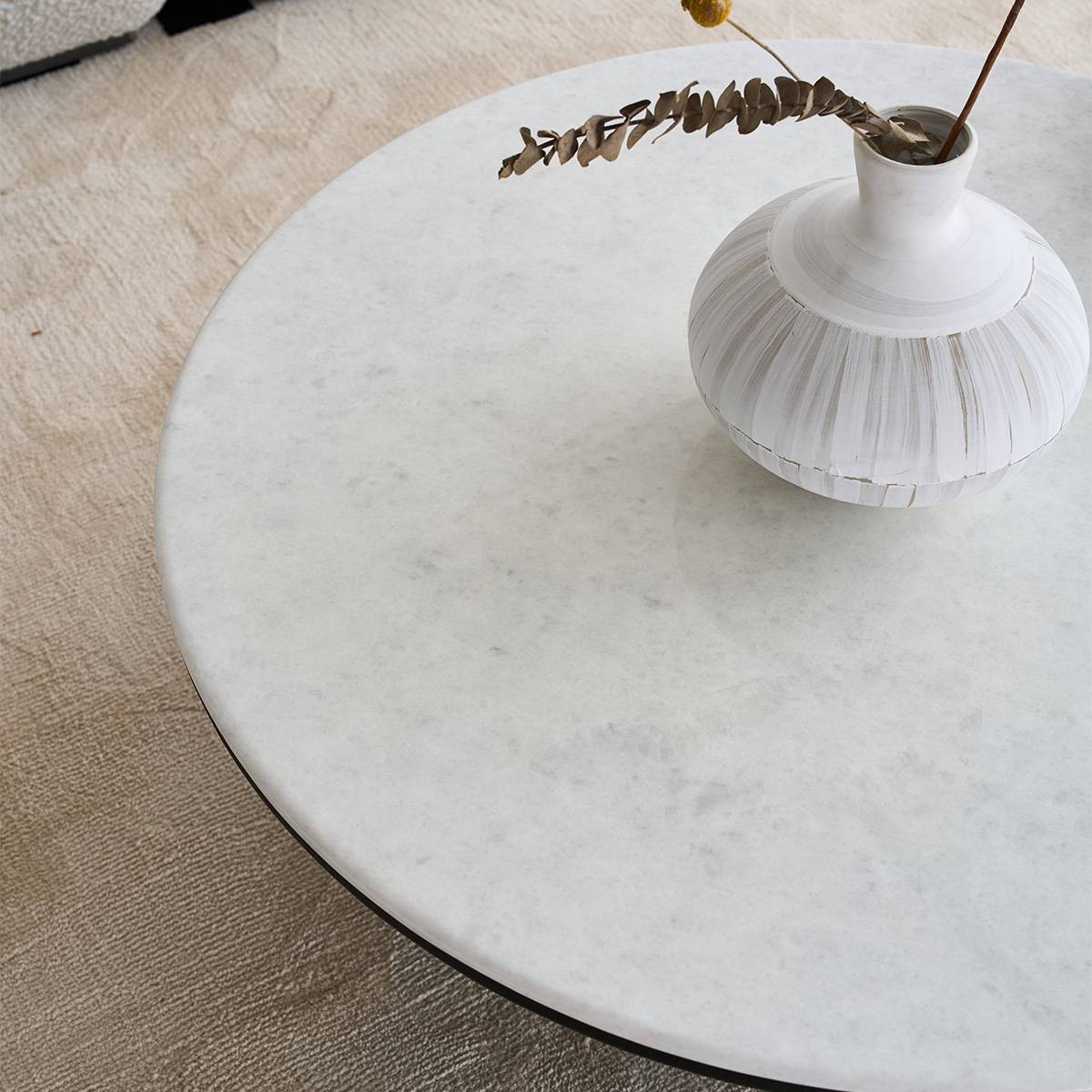 Close-up of the white natural stone table surface with a white vase.