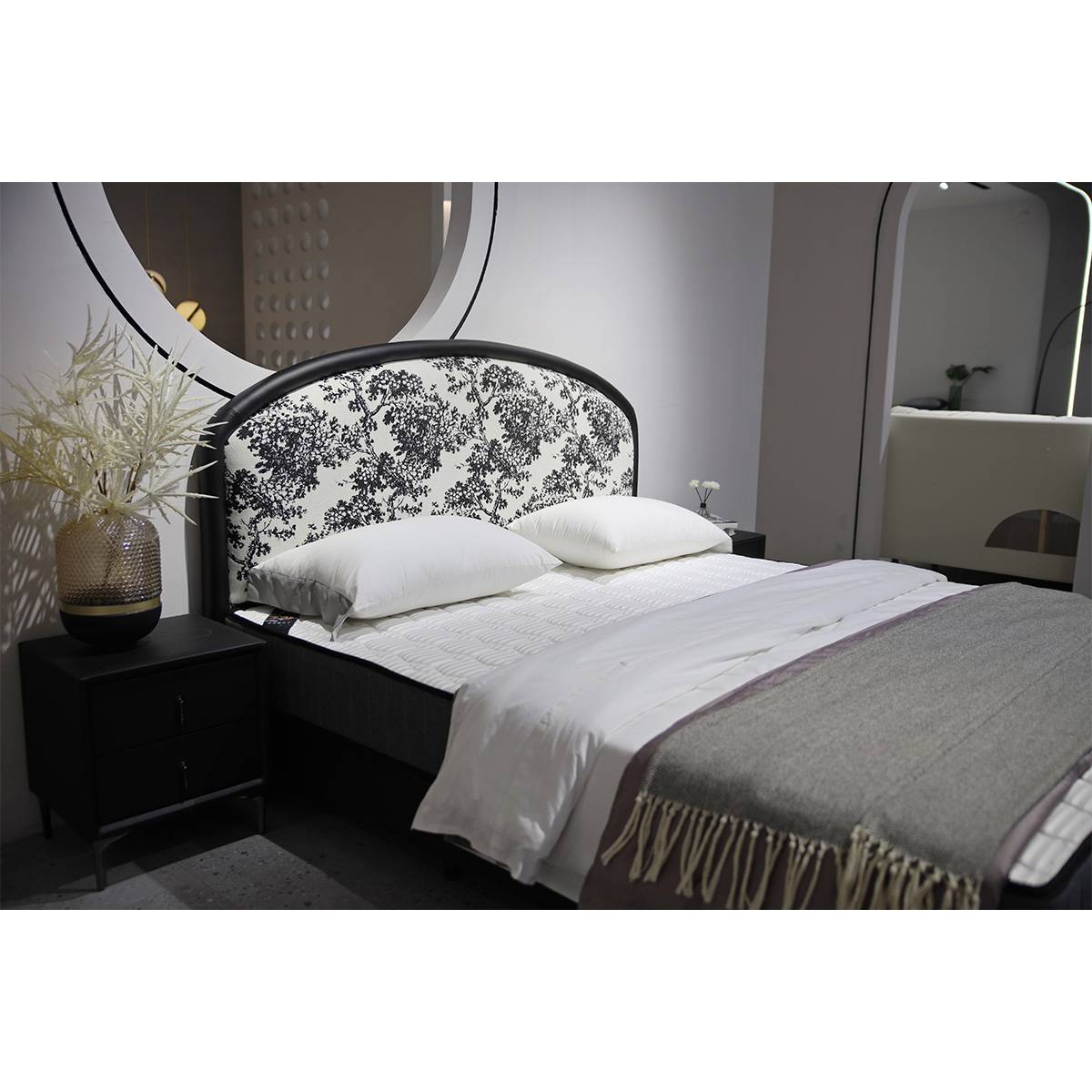 Close-up angle of the bed with bedside table and decorative plant