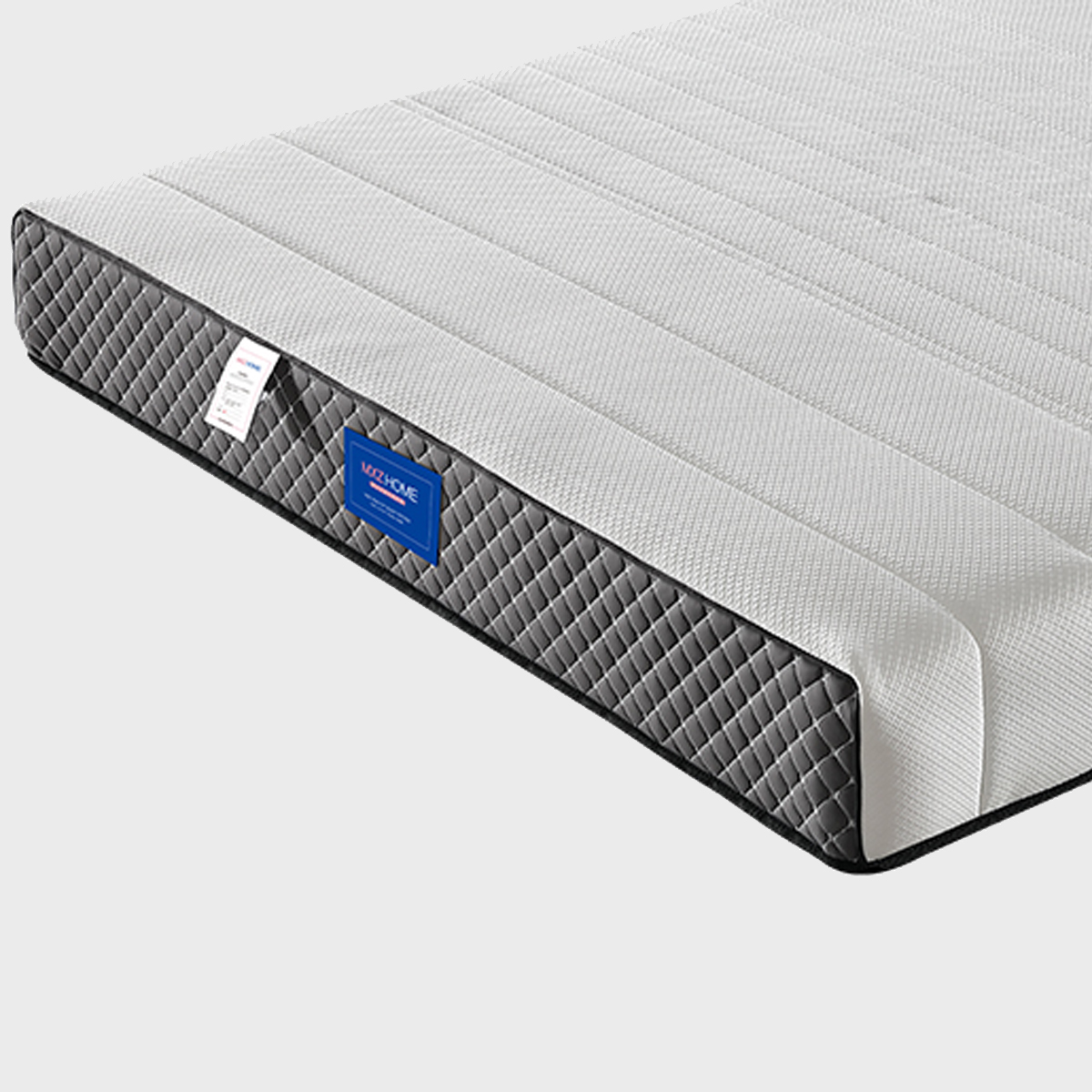 Close-up of mattress corner showing grey quilted side and blue label