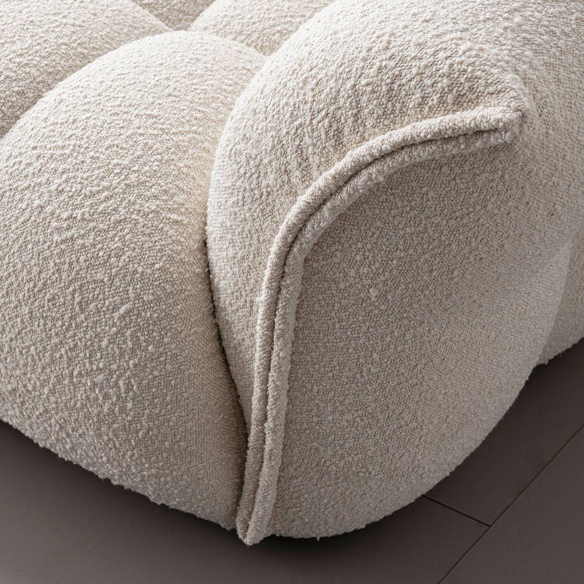 Close-up detail of the sofa armrest showing the boucle fabric texture