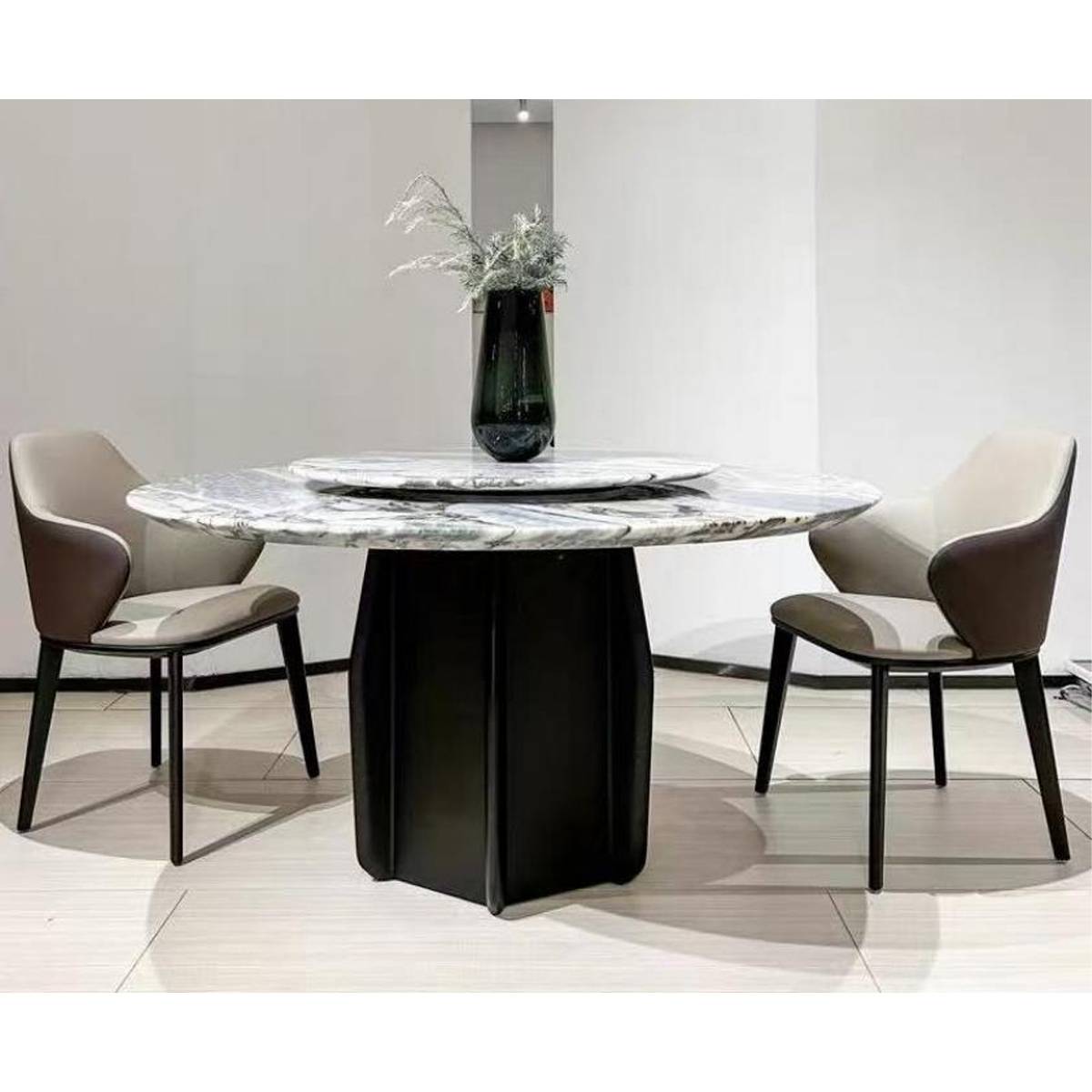 Full view of the round dining table with two dining chairs in a modern setting