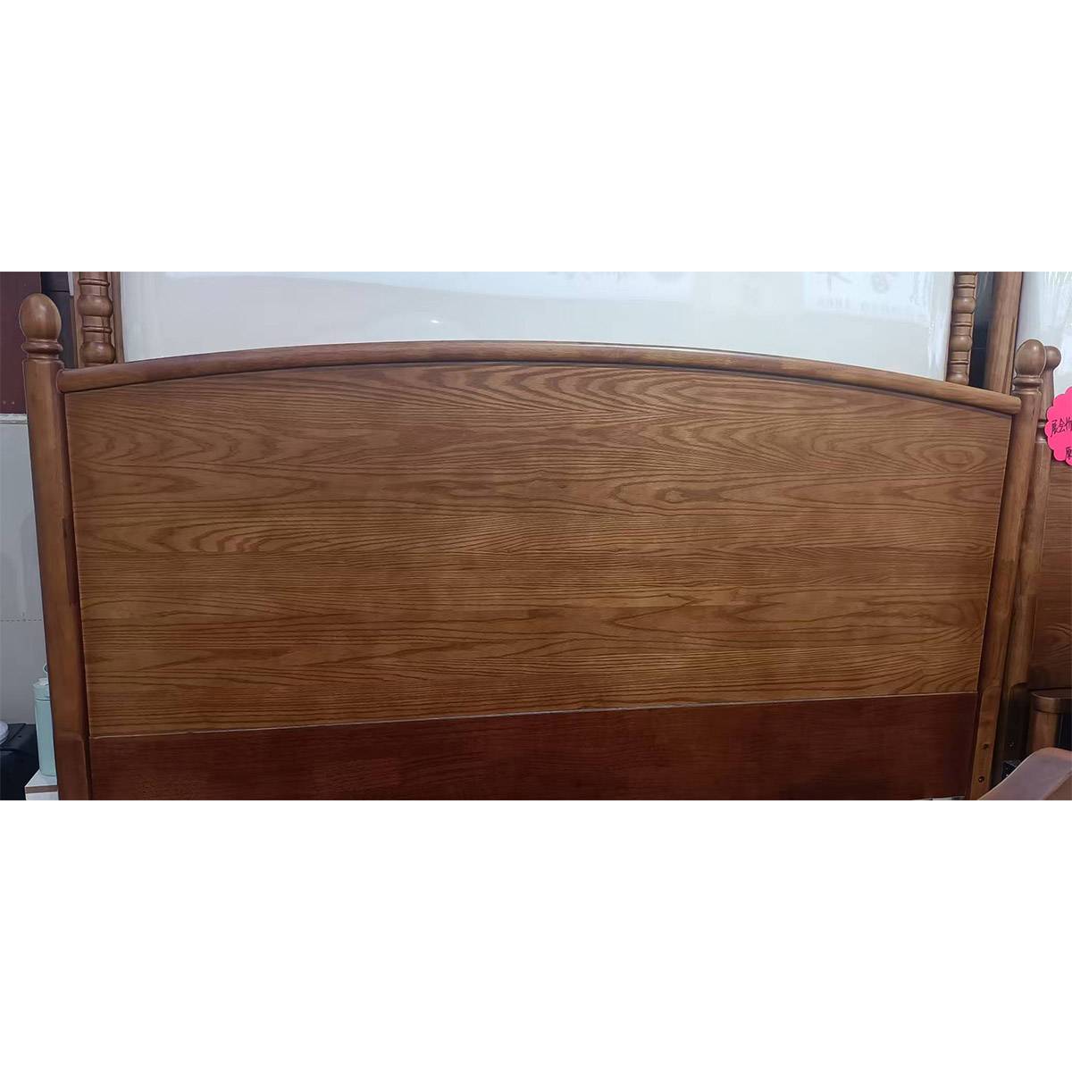 Close-up detail of the curved wooden headboard showing wood grain