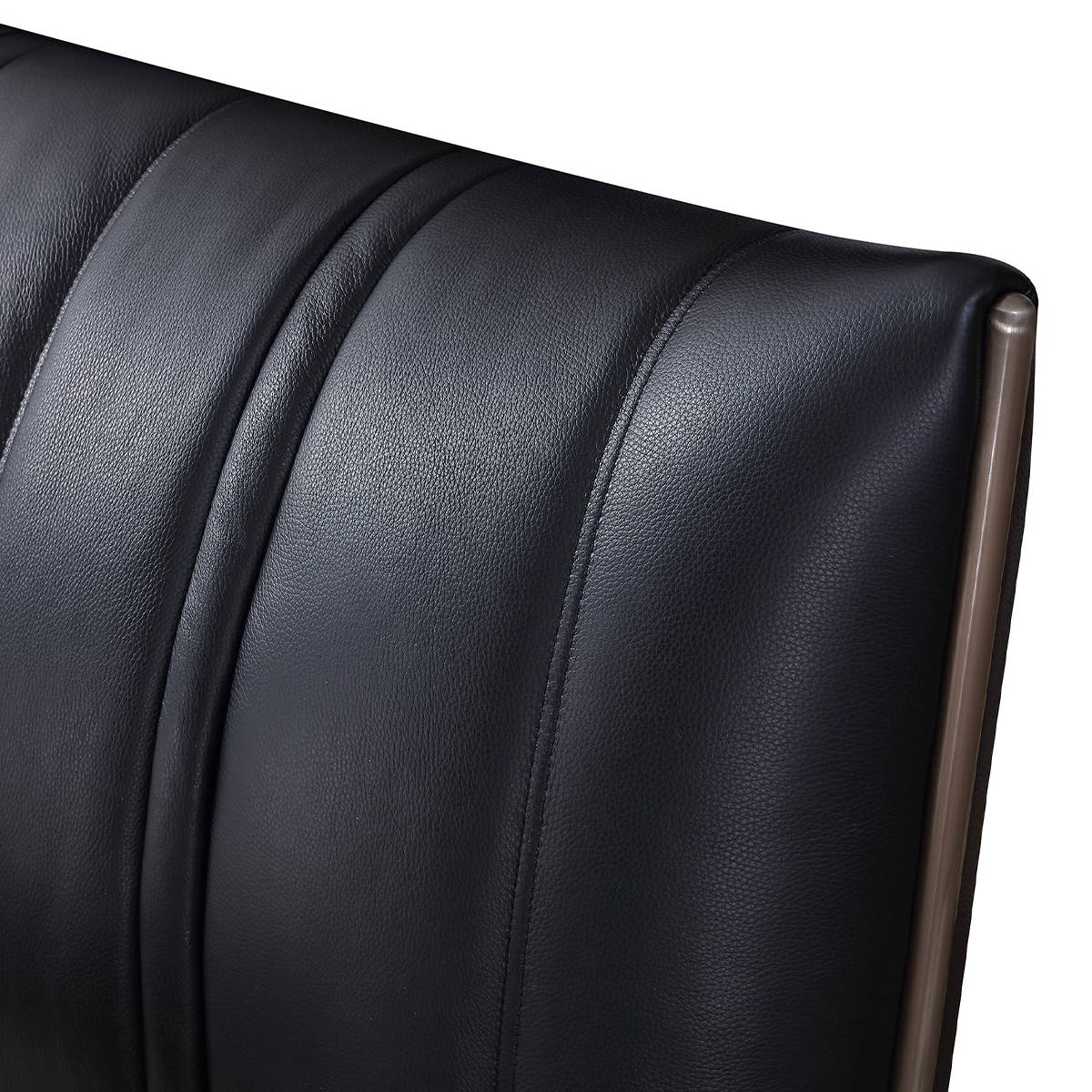Close-up detail of the black leather texture and stitching on the headboard