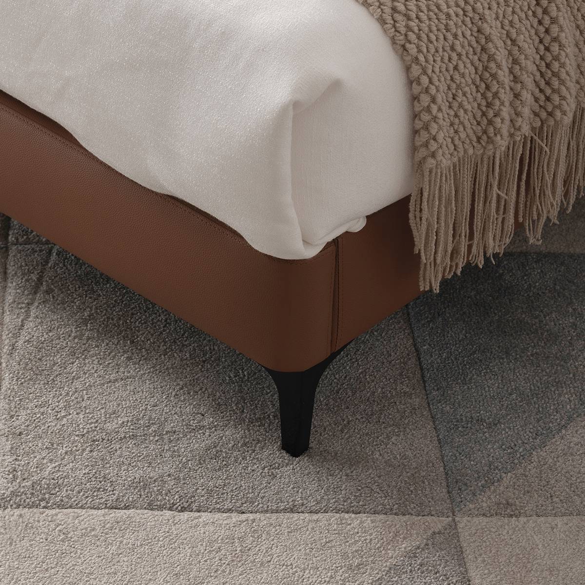 Close-up detail of the bed frame corner and black leg