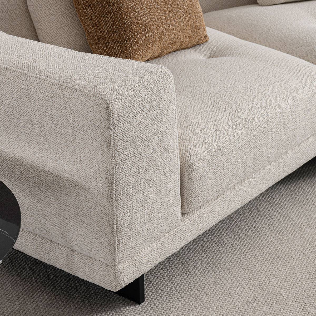 Detail of sofa armrest and black metal leg