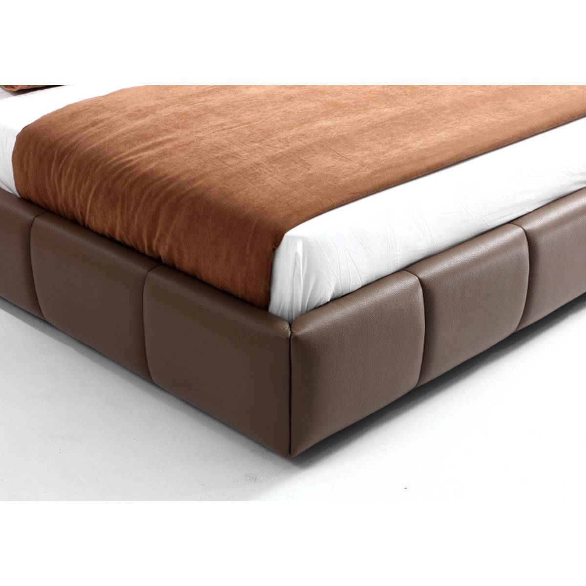 Close-up view of the brown leather bed base showing the tufted stitching and texture.