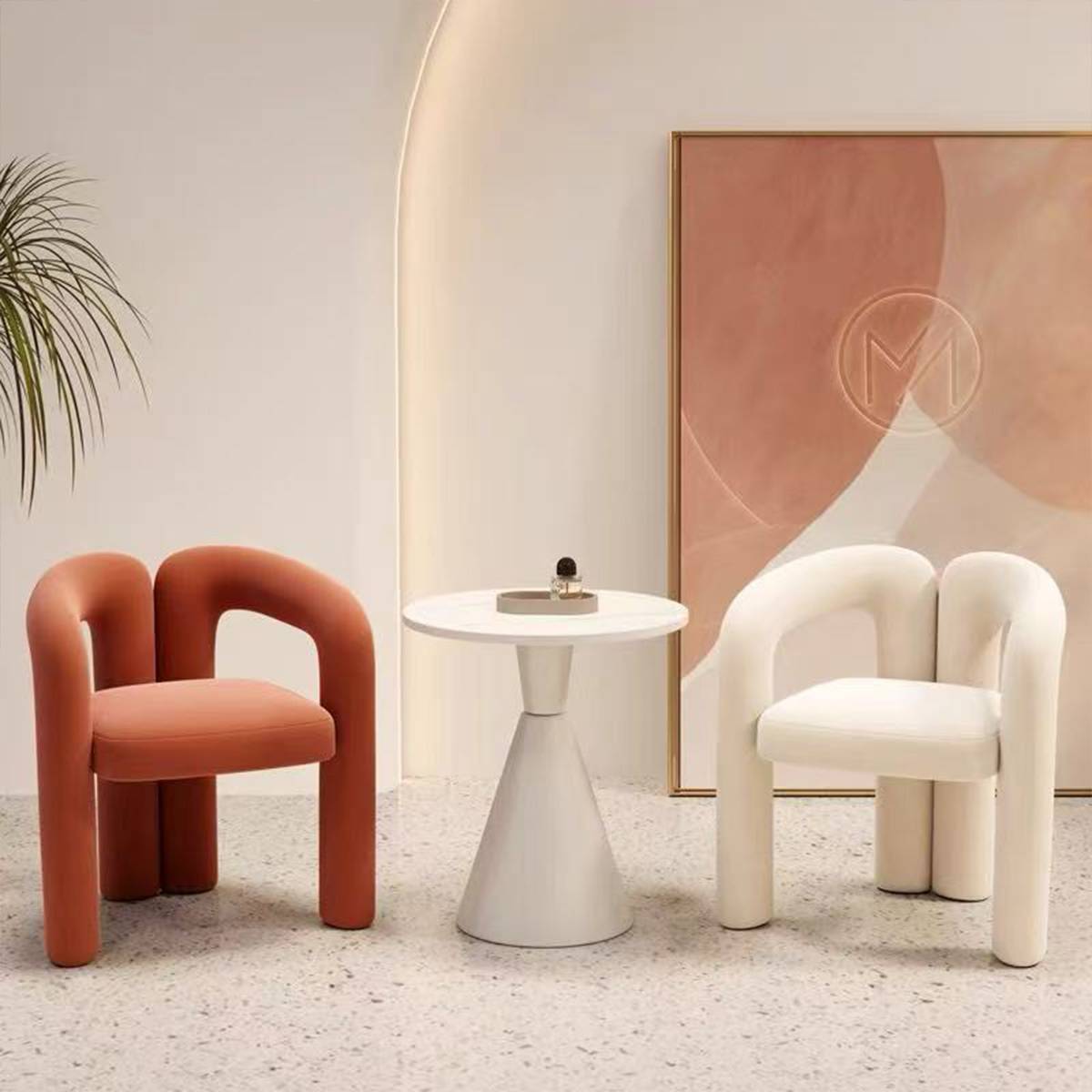 Orange and white lounge chairs with curved frames arranged around a side table