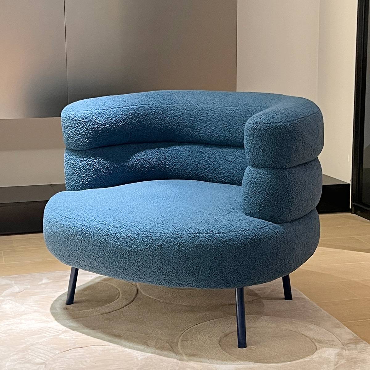Close-up angle of the blue lounge chair highlighting the fabric texture and frame structure