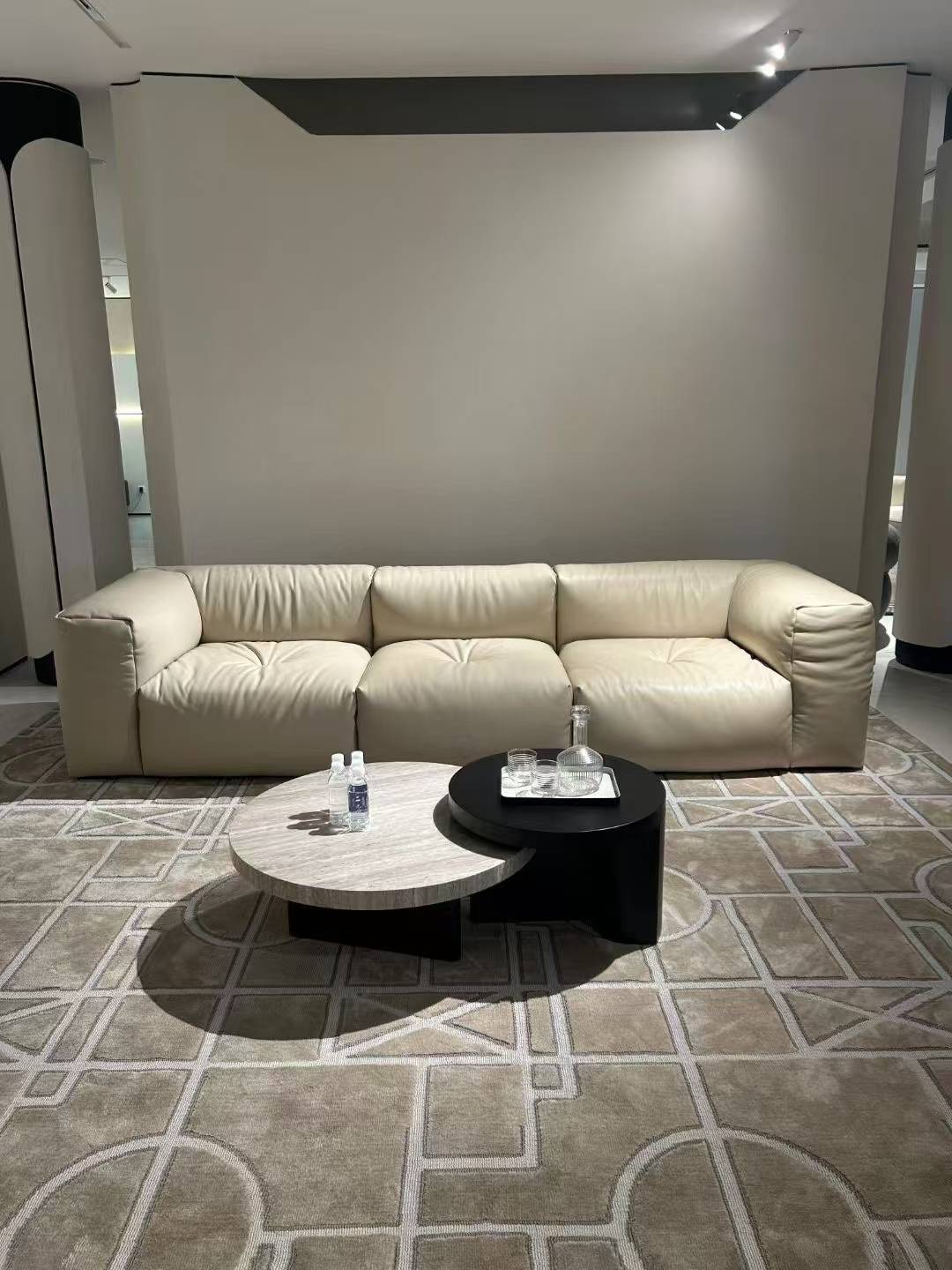 Nesting coffee tables in a living room setting with a beige sofa