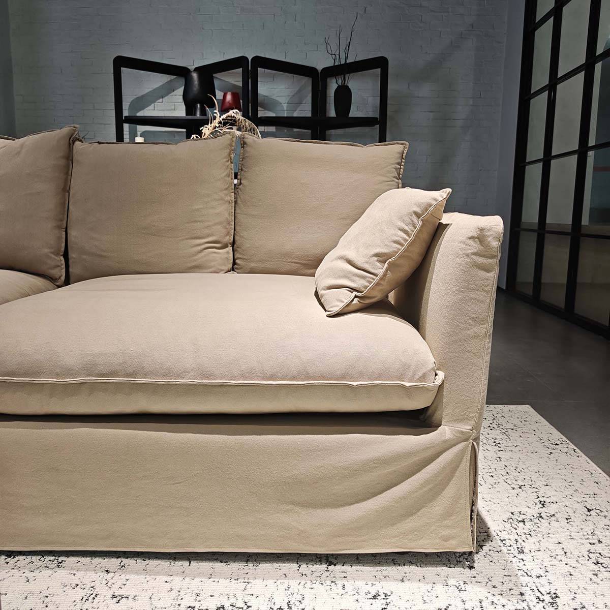 Close-up view of the beige fabric sofa seat and armrest showing the texture and cushioning.