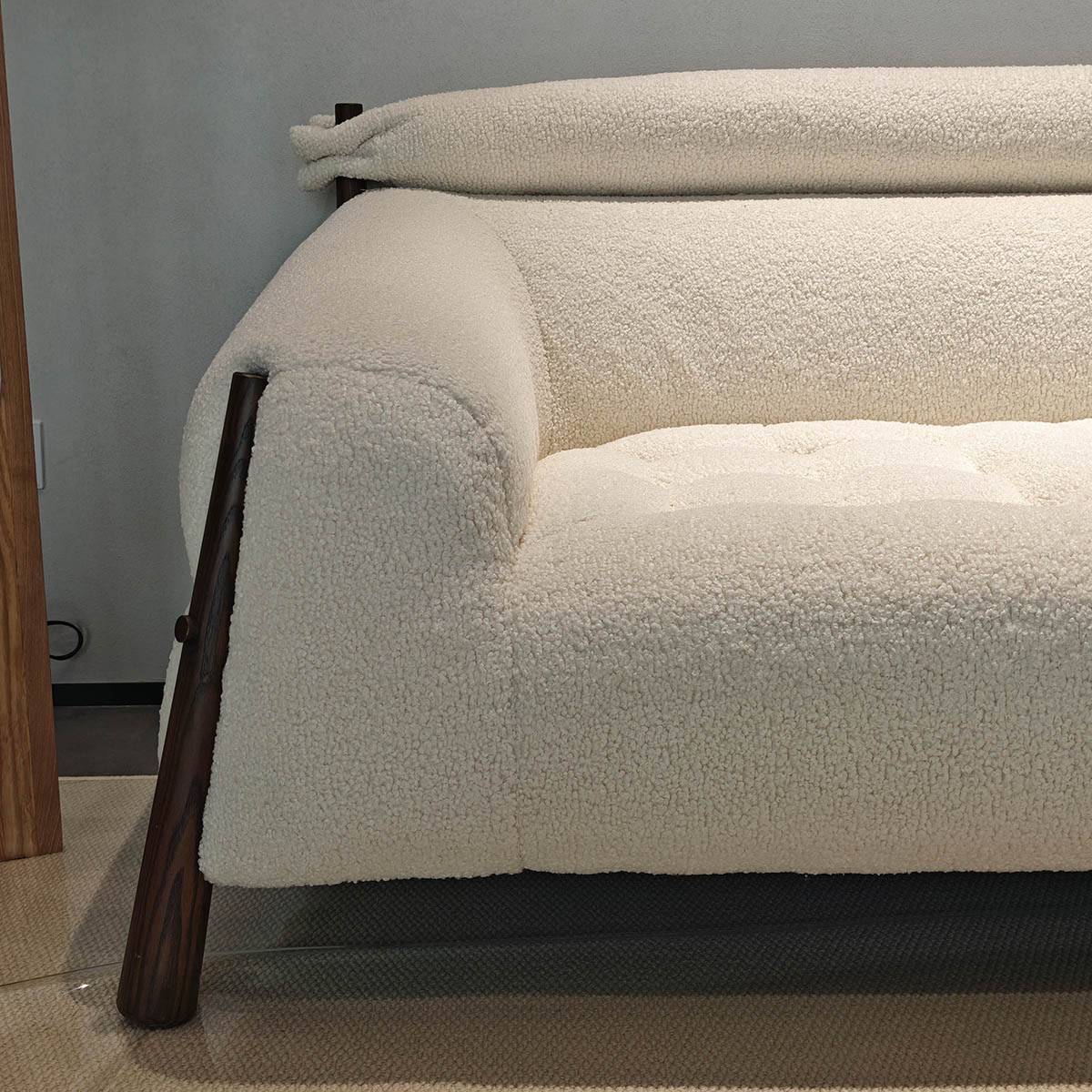 Close-up of the right side of the white bouclé sofa showing the tufted seat cushion