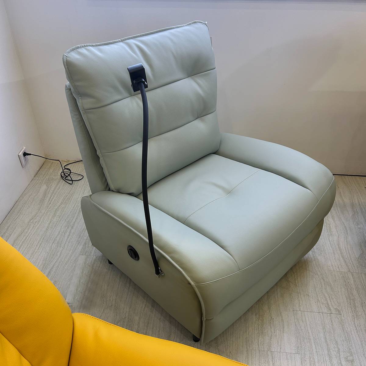 Close-up view of the electric recliner chair showing the control switch and upholstery texture