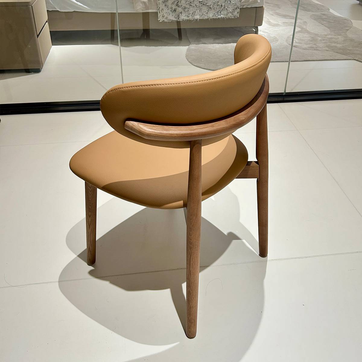 Side view of the dining chair showing the curved wooden armrest and back support