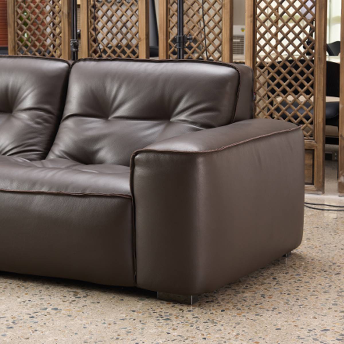 Side profile view of the sofa showing the armrest and charcoal black legs