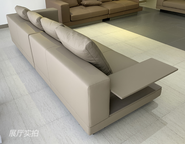 Side view of the beige sofa showing the side table and back cushions
